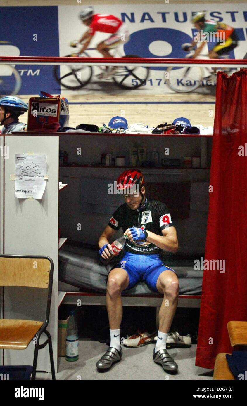 (dpa) - In the night Australian cyclist Scott McGrory takes a break in his booth while other competitors are continuing the race in the background, during the six days race in Dortmund, Germany, 5 November 2003. The team of McGrory and his German partner finished third. Stock Photo