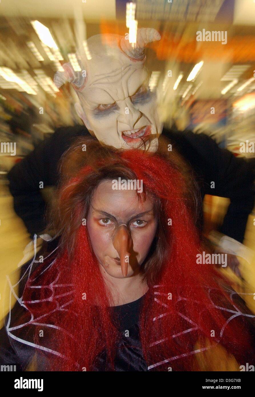 (dpa) - Shop assistants dressed up as a devil and a witch are scaring the customers in a Wal Mart supermarket in Hamburg, 31 October 2003. At the entrance, customers had to pass through a dark tunnel of horror draped with cobwebs and it became evident that shopping on Halloween was not a task for anxious people. Inside, the customers were greeted by a devil and for information they Stock Photo