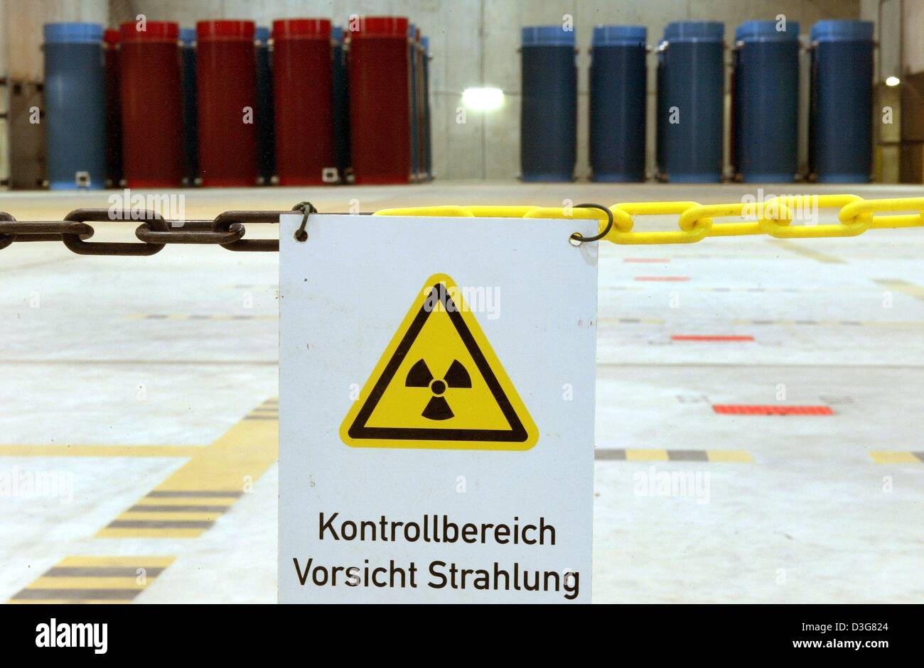 (dpa) - A sign which is labled with the symbole for nuclear hazard hangs attached to a chain which spanns across the storage room and reads 'Control Zone Caution Radiation' at the underground storage facility for nuclear waste in Gorleben, Germany   26 September 2003. In the background stand deposited containers with radioactive waste. The owner of the storage facility and the poli Stock Photo