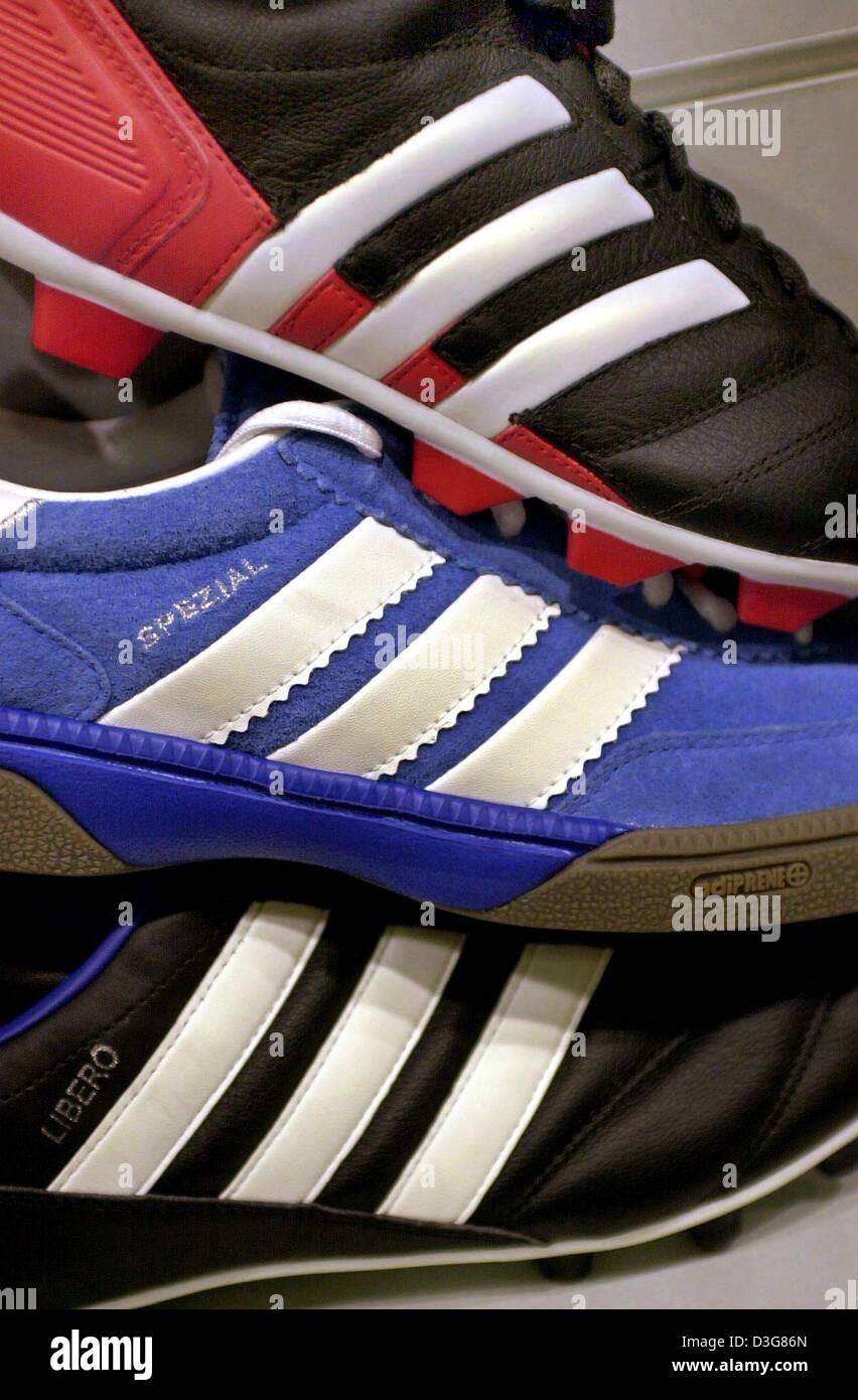 (dpa) - Three black, blue and red coloured trainers lie piled up on top of each other at a sports outfitters in Wuerzburg, Germany, 22 October 2003.  Adidas-Salomon, manufacturer of sports goods lost a court case about its company logo, the three white stripes. Fitnessworld Trading, a Dutch manufacturer of sports gear and wear was allowed to continue to lable is products with two w Stock Photo