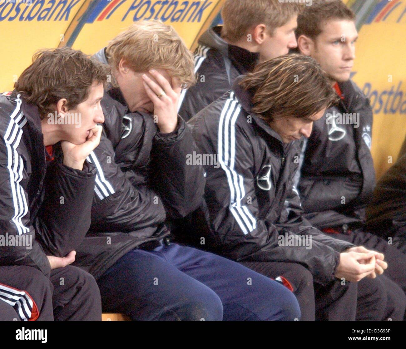 (dpa) - Germany's goalkeeper Oliver Kahn (2nd from L) covers his face with his hand sitting on the substitute bench during the match opposing Germany and Cameroon in Leipzig, Germany, 17 November 2004. From L sitting are: Frank Baumann, Kahn, Thomas Brdaric, Thomas Hitzlsberger and Moritz Volz. Germany won 3-0. Stock Photo