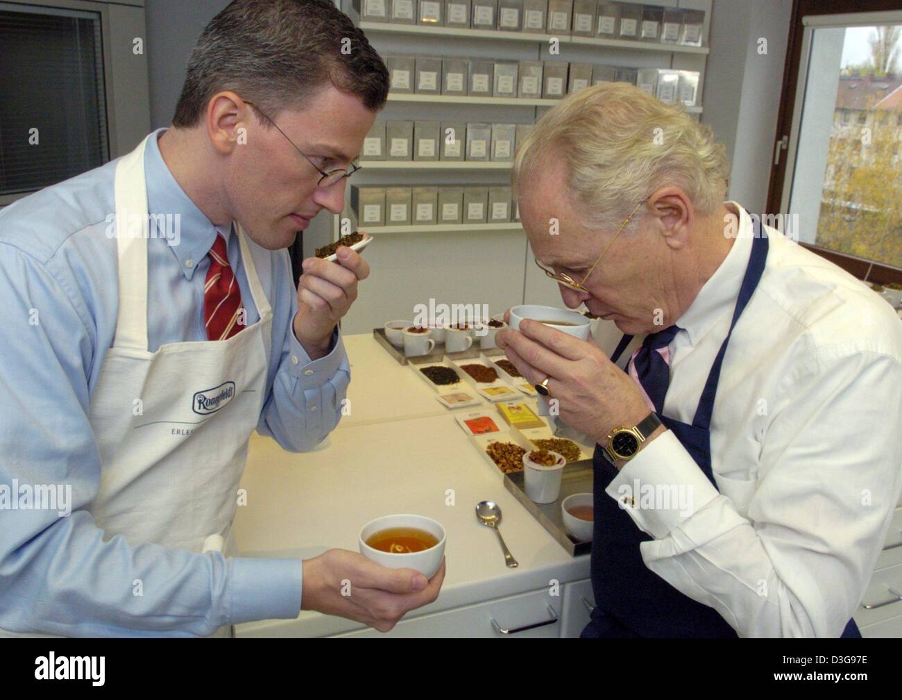 (dpa) - Senior chairman Frank Holzapfel and his son Jan-Berend Holzapfel smell at a blend to determine the different flavours of tea at the Ronnefeldt tea trading house in Frankfurt, Germany, 11 November 2004. Ronnefeldt, world famous for the highest quality in tea, supplies a large number of first class hotels in Europe and increasingly throughout the world, including Hotel Adlon  Stock Photo