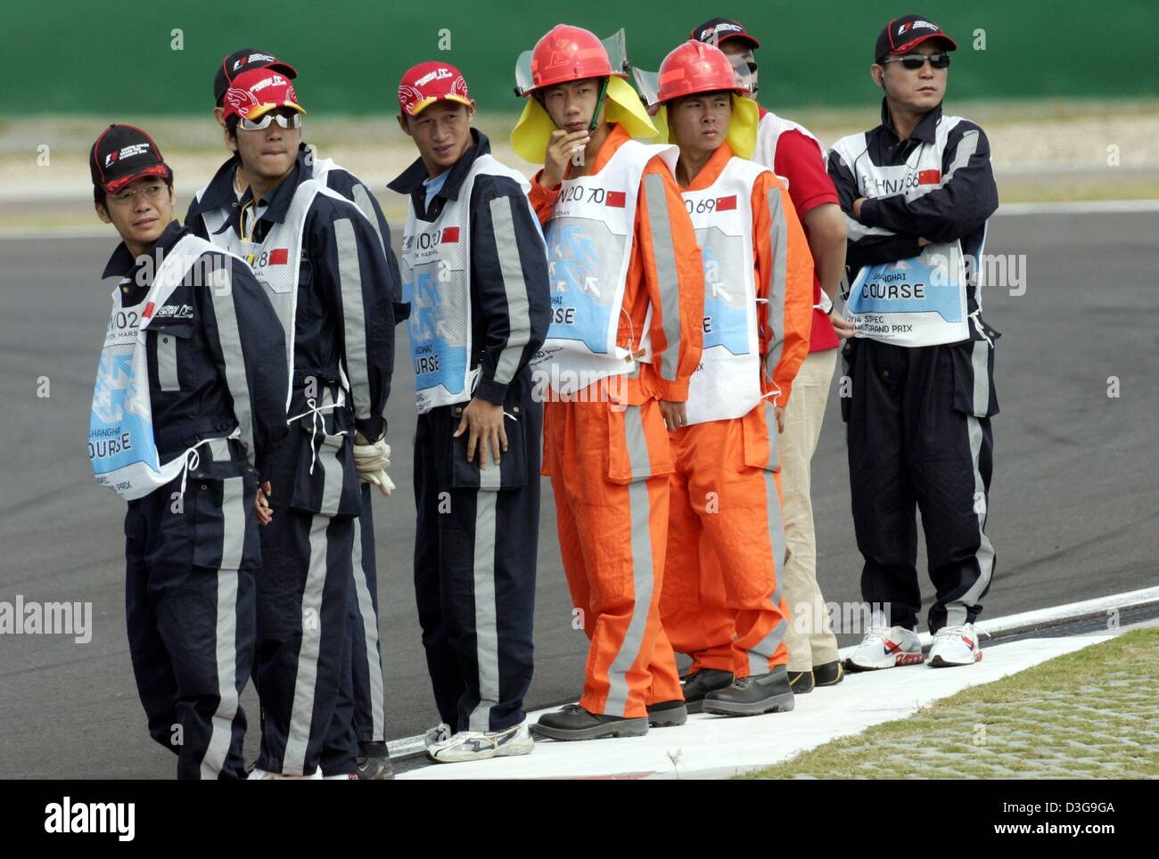 (dpa) - Race marshalls turn around as they wait for the start of the free practice session at the Shanghai International Circuit, in Shanghai, China, Friday, 24 September 2004. Sunday's race will be the first time a Grand Prix is staged in China. Stock Photo