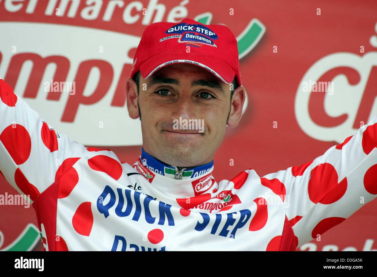 (dpa) - Italian cyclist Paolo Bettini (C) of team Quick Step-Davitamon celebrates after the second stage of the Tour de France in Namur, Belgium, 5 July 2004. The second and 197km long stage of the 91st Tour de France cycling race took the cyclists from Charleroi to Namur. Bettini successfully defended the red polka dot jersey which is worn by the best mountain climber. Stock Photo