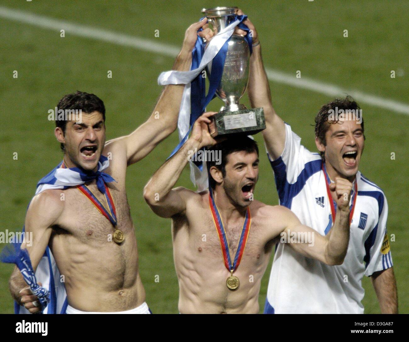 (dpa) - Greek players Traianos Dellas, Georgios Karagounis and Zisi Vryzas (from L) hold up the trophy which is draped with the Greek colours after the Euro 2004 soccer final between Portugal and Greece at Luz Stadium in Lisbon, Portugal, 4 July 2004. Greece, which had never before won a European Championship or World Cup match, wrote footballing history with their memorable 1-0 vi Stock Photo