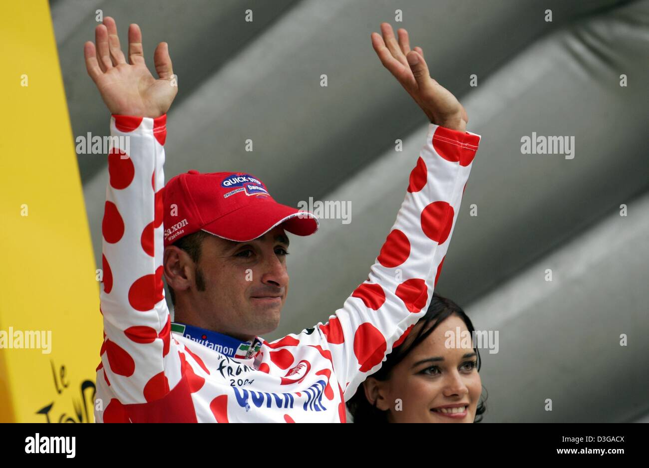 (dpa) - Italian Paolo Bettini of Quick Step-Davitamon waves from the podium after putting on the best climber's white and red polka-dotted jersey after the first stage of the Tour de France in Charleroi, Belgium, 4 July 2004. The first and 202.5km long stage of the 91st Tour de France cycling race took the cyclists from Liege to Charleroi. Stock Photo