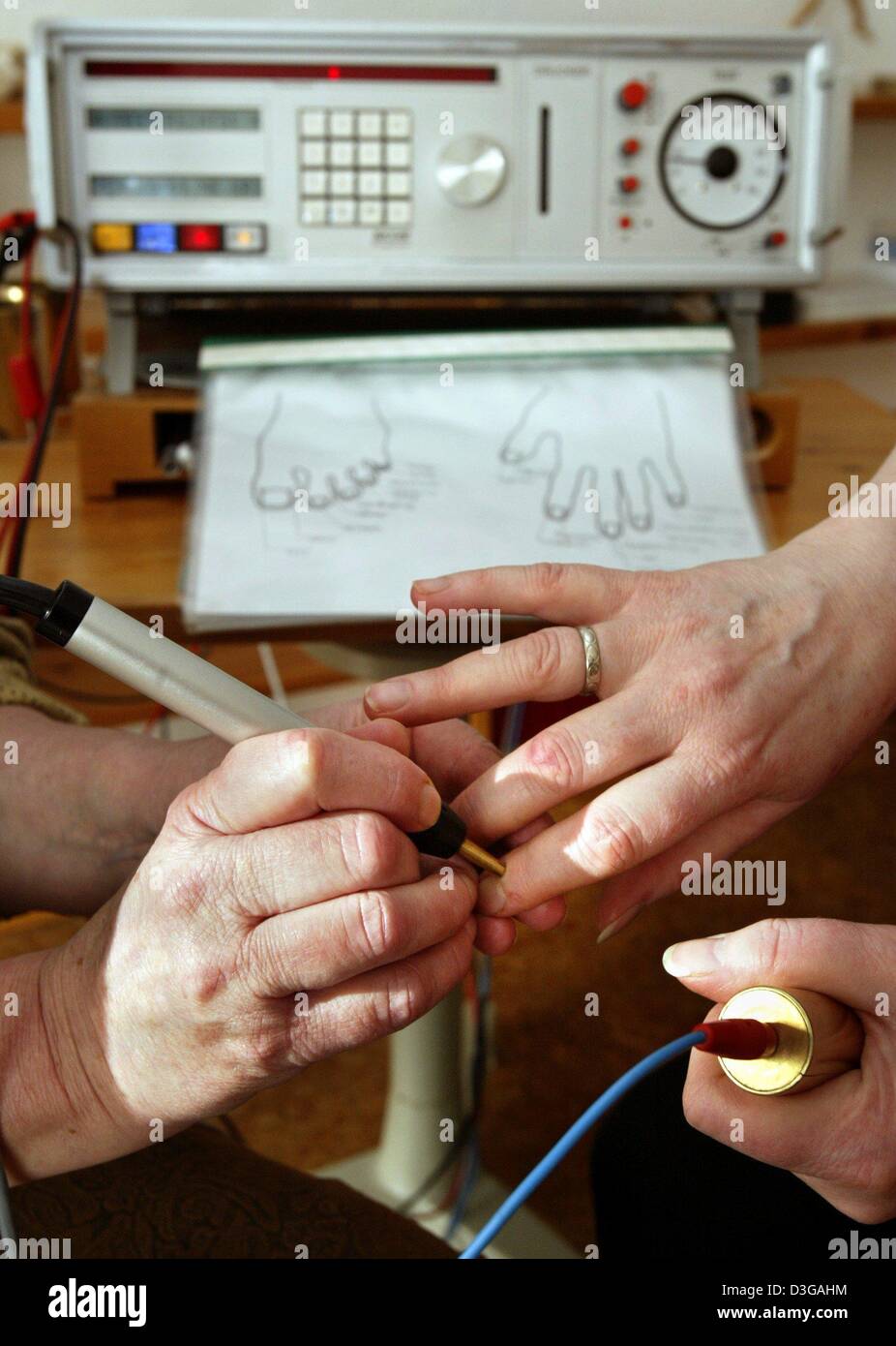A naturopath (L) conducts a bio-resonance therapy on the hand of a patient at the practice of an alternative practitioner in Schoeneck-Kilianstaedten, Germany, 29 January 2004. Bio-resonance therapies belong to the field of energetic treatments. Researches have been analysing the distinct wave patterns, or oscillations, of functioning body systems and organs as well as those of ant Stock Photo