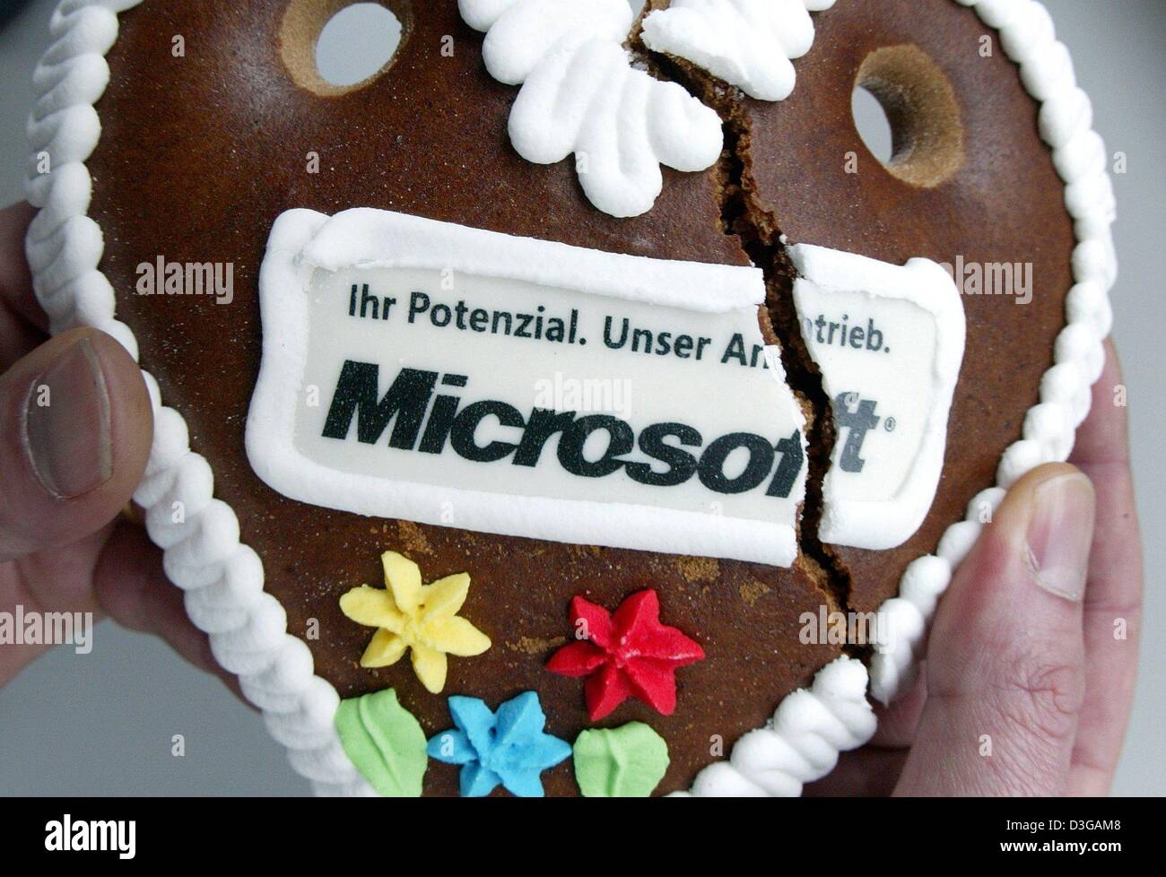 (dpa) - A Microsoft gingerbread heart is broken at the world's largest computer trade fair CeBit in Hanover, Germany, on Wednesday, 24 March 2004. The gingerbread hearts carrying the Microsoft logo and the slogan 'Ihr Potenzial. Unser Antrieb' (your potential. our incentive) were out of stock by noon. The European Commission on Wednesday slapped a record fine of 497 million euros o Stock Photo