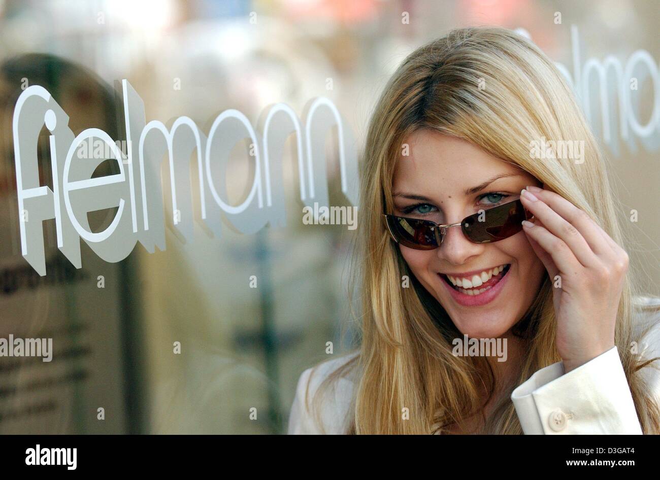 (dpa) - Model Theresa smiles as she presents a pair of sunglasses by Fielmann AG in Hamburg, Germany, 28 April 2004. Fielmann AG achieved pre-rax earnings of 112 million euros in the 2003 business year which marks an increase by 78 percent. The company, which is already covering a large market share in Germany, is now aiming to expand its business activities in Europe. Stock Photo