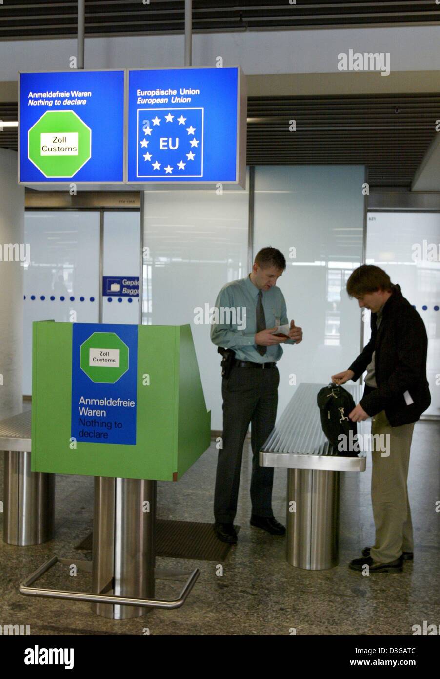 (dpa) - A customs officer at a customs checkpoint inspects the luggage and documents of a traveller at the airport in Frankfurt, Germany, 20 April 2004. In the past, several customs checkpoints at Germany's largest airport had been unoccupied, but officials claimed that supervision had been sufficient due to random checks that were regularly performed. Stock Photo
