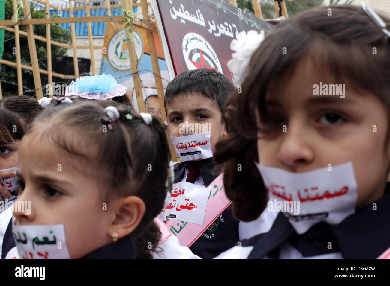 Feb. 19, 2013 - Gaza City, Gaza Strip, Palestinian Territory - Palestinian children cover their mouth with a sticker during a rally to show solidarity with Palestinian prisoners on hunger strike in Israeli jails, in Gaza City February 19, 2013. The sticker reads:''Yes to hunger, no to kneeling  (Credit Image: © Ashraf Amra/APA Images/ZUMAPRESS.com) Stock Photo