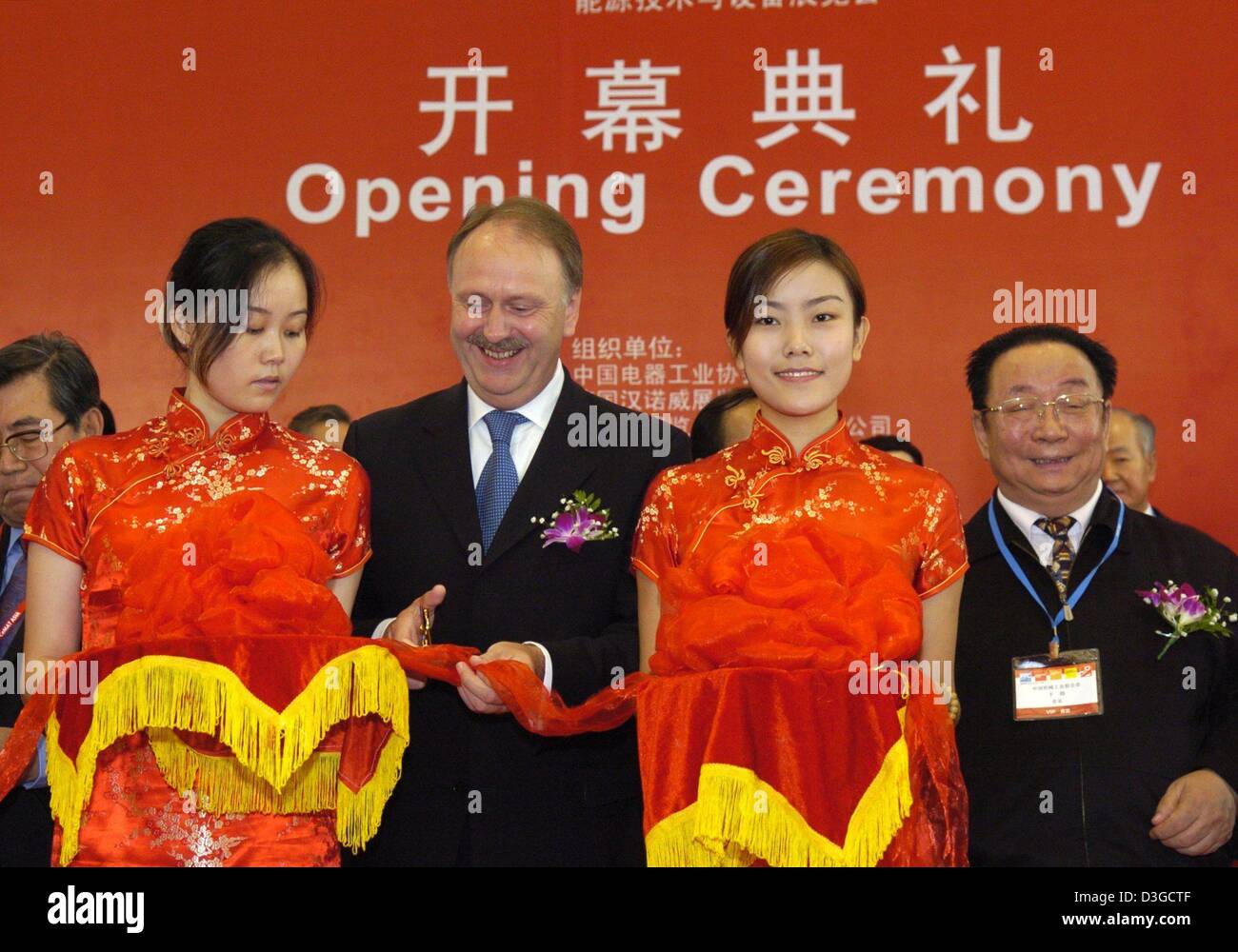 (dpa) -  The head of the Deutsche Messe AG (German trade fair group), Ernst Raue (2nd from L), and Yu Zhen (R), President of the Chinese Machine Industry Federation, smile as they officially open the trade fair week at the new 'Shanghai New International Expo Centre' (SNIEC) in Shanghai, China, 12 October 2004. The Deutsche Messe AG is organizing five trade fairs from the spectrum  Stock Photo