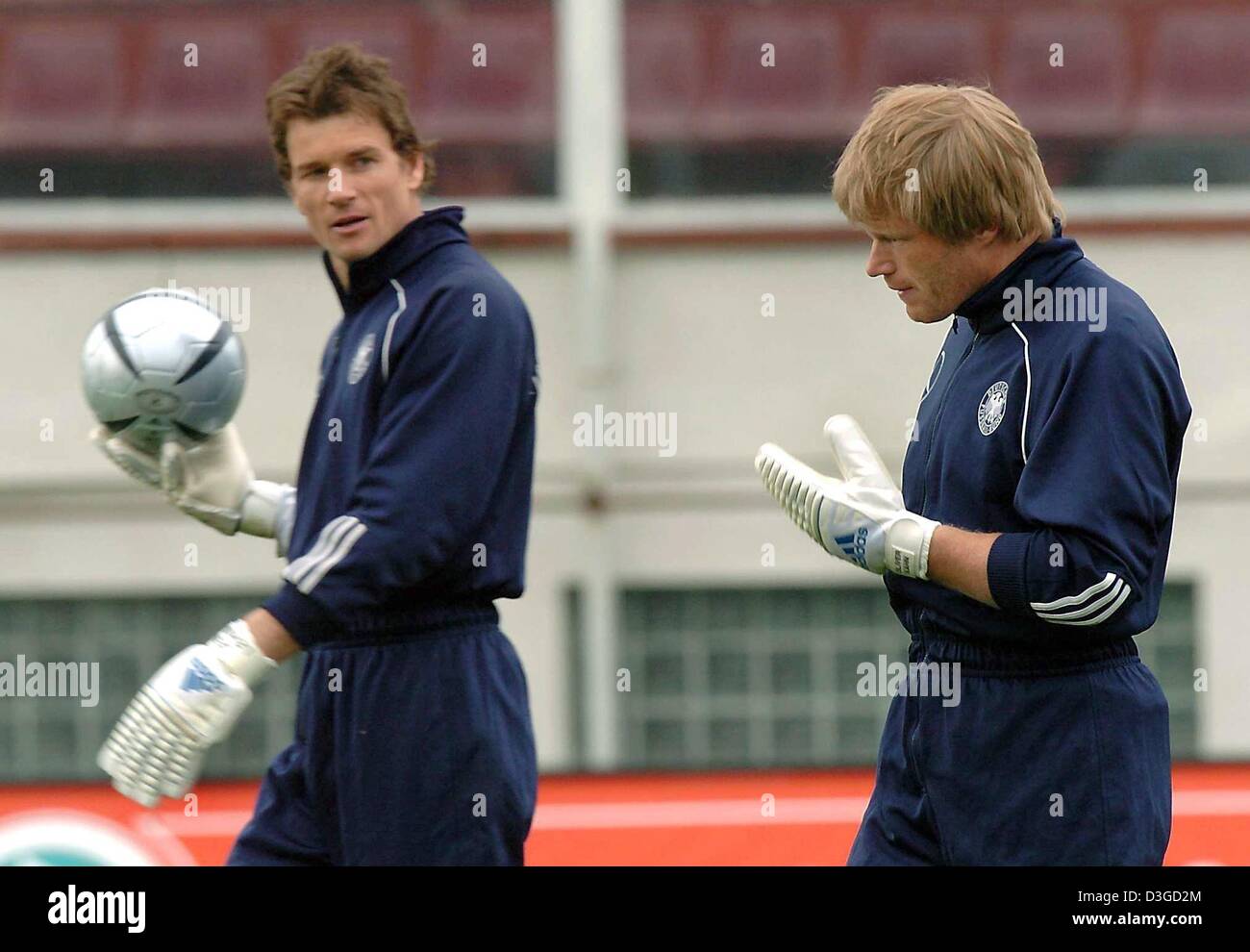 (dpa files) - German national team goalkeepers Jens Lehmann (l) and Oliver Kahn walk across the pitch during a training session in Bucharest, Romania, 27 April 2004. The fight for the top goalkeeping spot on the German national team has been revived before Germany's scheduled international friendly match against Iran in Tehran on 9 October 2004. Kahn and Lehmann have been fighting  Stock Photo