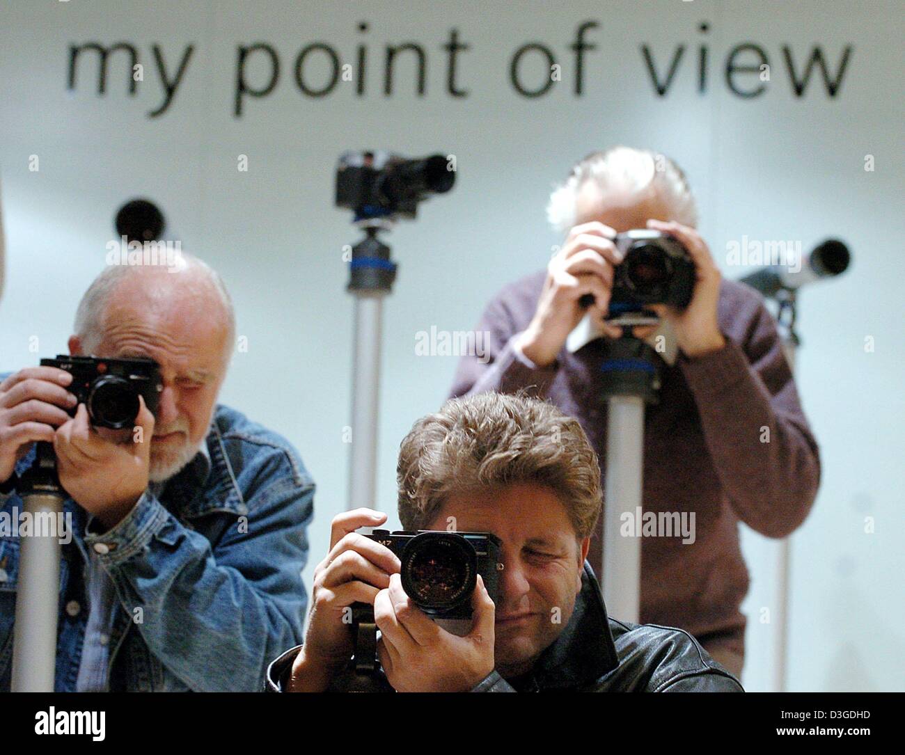 Visitors try out Leica cameras at the trade fair in Cologne, Germany ...