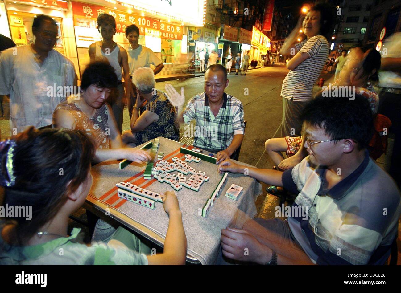 (dpa files) - People play the traditional Mah-Jongg game on a makeshift table in a street in central Shanghai, China, 16 July 2004. The Grand Prix of China will be held on the newly built race track for the first time in Shanghai on Sunday, 26 September 2004. Stock Photo
