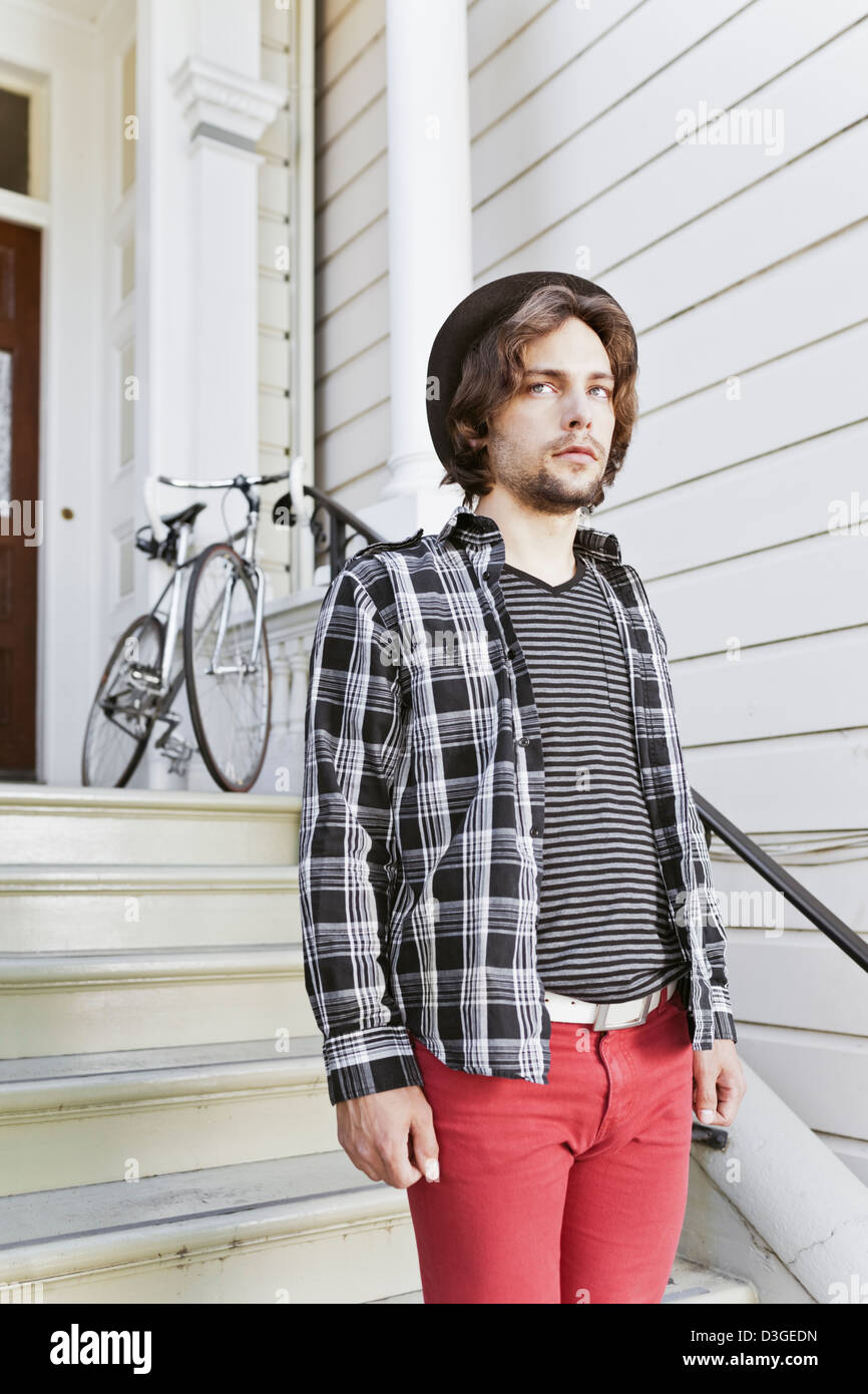Hipsters and Beatniks - A young hipster man in tight jeans, plaid shirt,  and hat about to leave home in his fixed-gear bike Stock Photo - Alamy