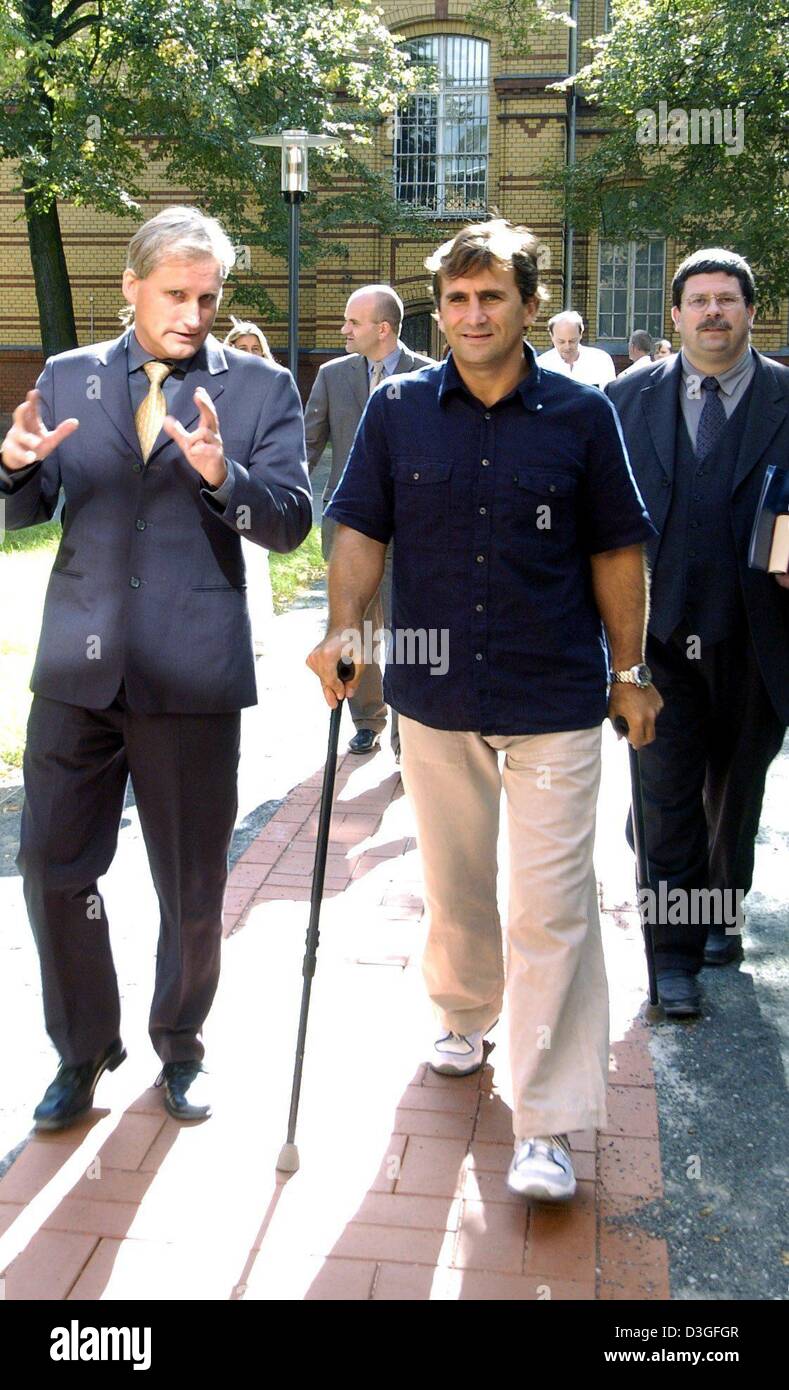 (dpa) - Race car driver Alex Zanardi walks on crutches as he arrives at the emergency hospital in Berlin, Germany, 16 September 2004. Zanardi had lost both legs in a crash at Lausitzring race course on 15 September 2001 and wanted to personally present his book to the doctors and nurses at the hospital who had helped save his life after the crash. In the book titled 'Alex Zanardi:  Stock Photo