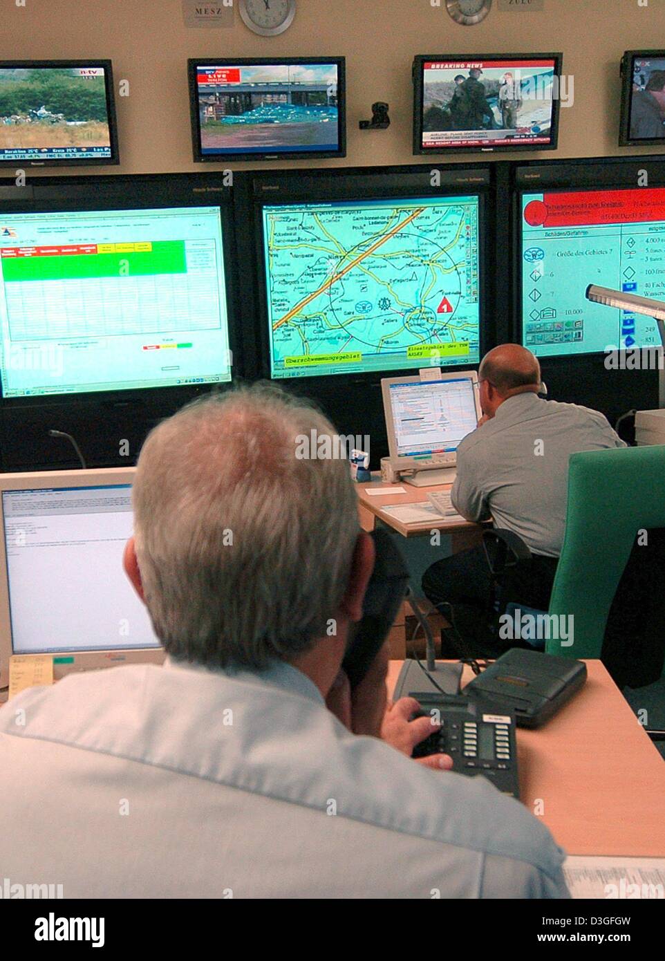 (dpa) - Employees observe newsfeeds and television screens in the crisis center at the Federal Bureau of Civil Defence and Disaster Relief in Bonn, Germany, 25 August 2004. For the most part kept quiet from the general public, hundreds of security experts are training and preparing for 'day x'. Aside from natural desasters such as floods or storms, that day could also involve a ter Stock Photo