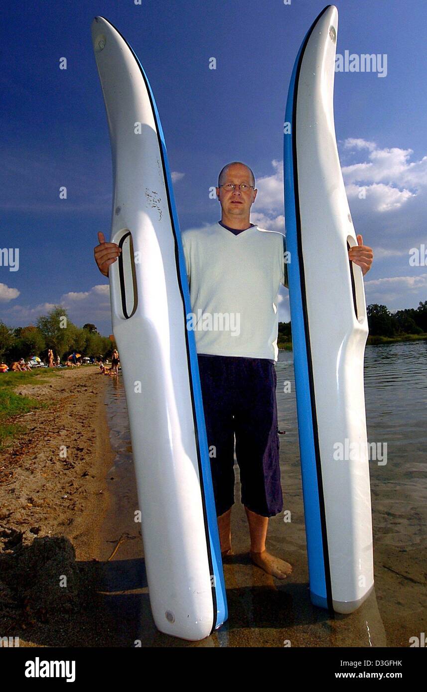 dpa) - Frank Schack holds up two large oversized floating shoes at the  Pinnower lake in Godern, Germany, 7 September 2004. The so-called 'sea  walking' is a new trend sports that can