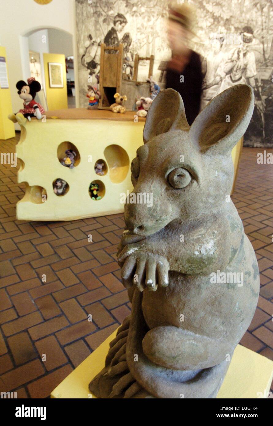 (dpa) - A mouse sculpture sits in front of an oversized piece of cheese during the 'Mouse, Man and Mouse Trap' exhibition at Grafschafter Museum at Moers Castle, Germany, 20 August 2004. Next to plush, metal and paper mice there will also be many mouse drawings on display at the exhibition which lasts until 1 November 2004. Stock Photo