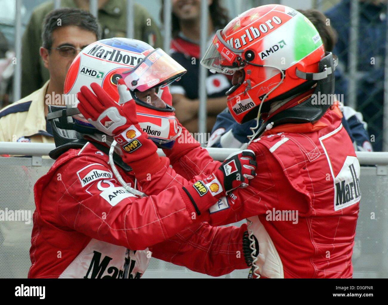 (dpa) - Ferrari Formula 1 drivers Rubens Barrichello (L) from Brazil and his German teammate Michael Schumacher (R) jubilate after the end of the Italian Grand Prix in Monza, Italy, 12 September 2004. Barrichello won the race with Schumacher coming in second to give Ferrari its 9th 1-2 finish of the current racing season. Stock Photo