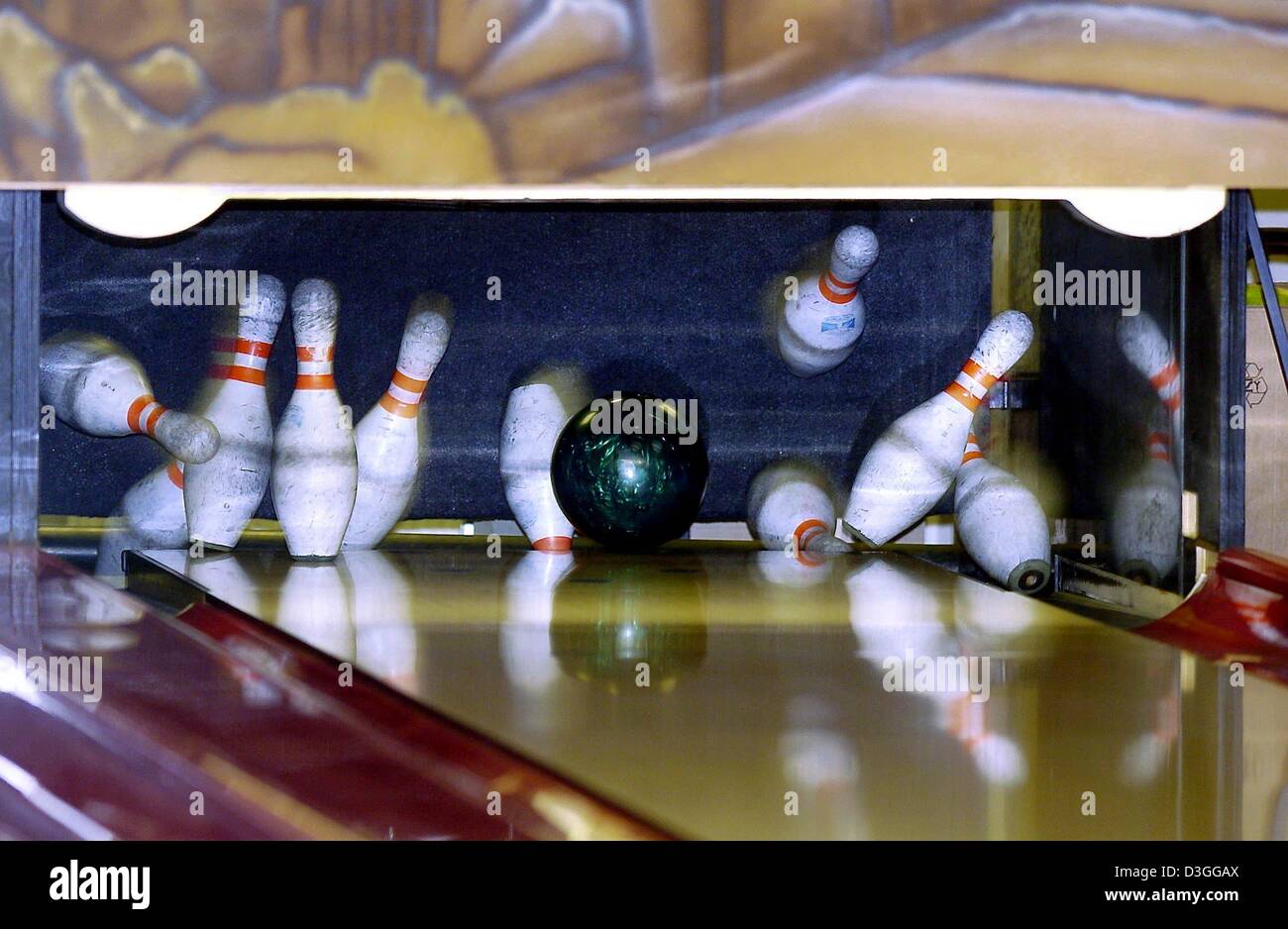 (dpa) - A bowling ball crashes into the pins at a bowling alley in Berlin, Germany, 26 August 2004. Bowling is a popular recreational activity loved by young and old. The rules are simple with each game lasting ten 'frames' in which each player, or bowler, has two tries to roll the bowling ball down a wooden or artificial lane and knock over ten wooden pins. The bowling lane is 18. Stock Photo
