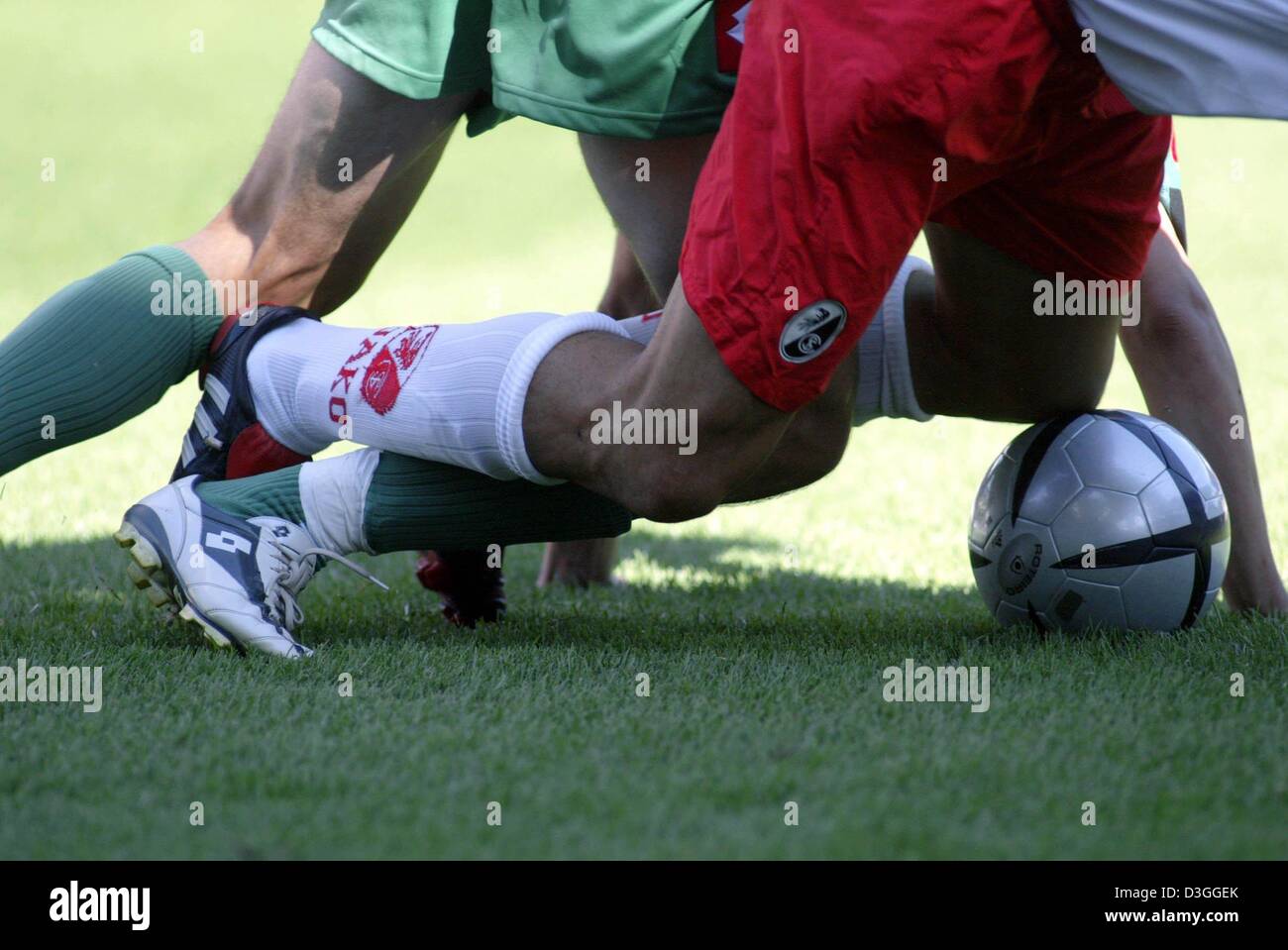(dpa) - The legs of two soccer players get tangled up in a fight for the ball in a German Bundesliga match between SC Freiburg and Borussia Moenchengladbach at Badenova Stadium in Freiburg, Germany, 28 August 2004. Stock Photo
