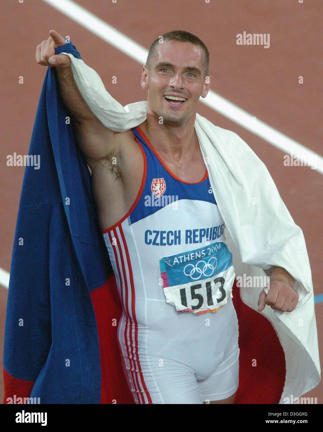 (dpa) - Roman Sebrle from the Czech Republik smiles and cheers with the Czech flag in his hands after winning the gold medal the men's 1500m Decathlon at the Olympic stadium during the 2004 Olympic Games in Athens, Greece, 24 August 2004. Stock Photo