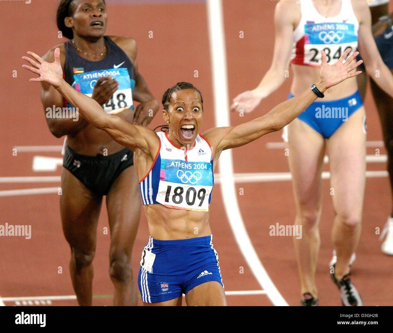 (dpa) - Kelly Holmes (C) from Great Britain jubilates as she crosses the finish line ahead of Mozambique's Maria de Lurdes Mutola (L) to win the gold medal in the women's 800m at the 2004 Olympic Games in Athens, Greece, 23 August 2004. Stock Photo