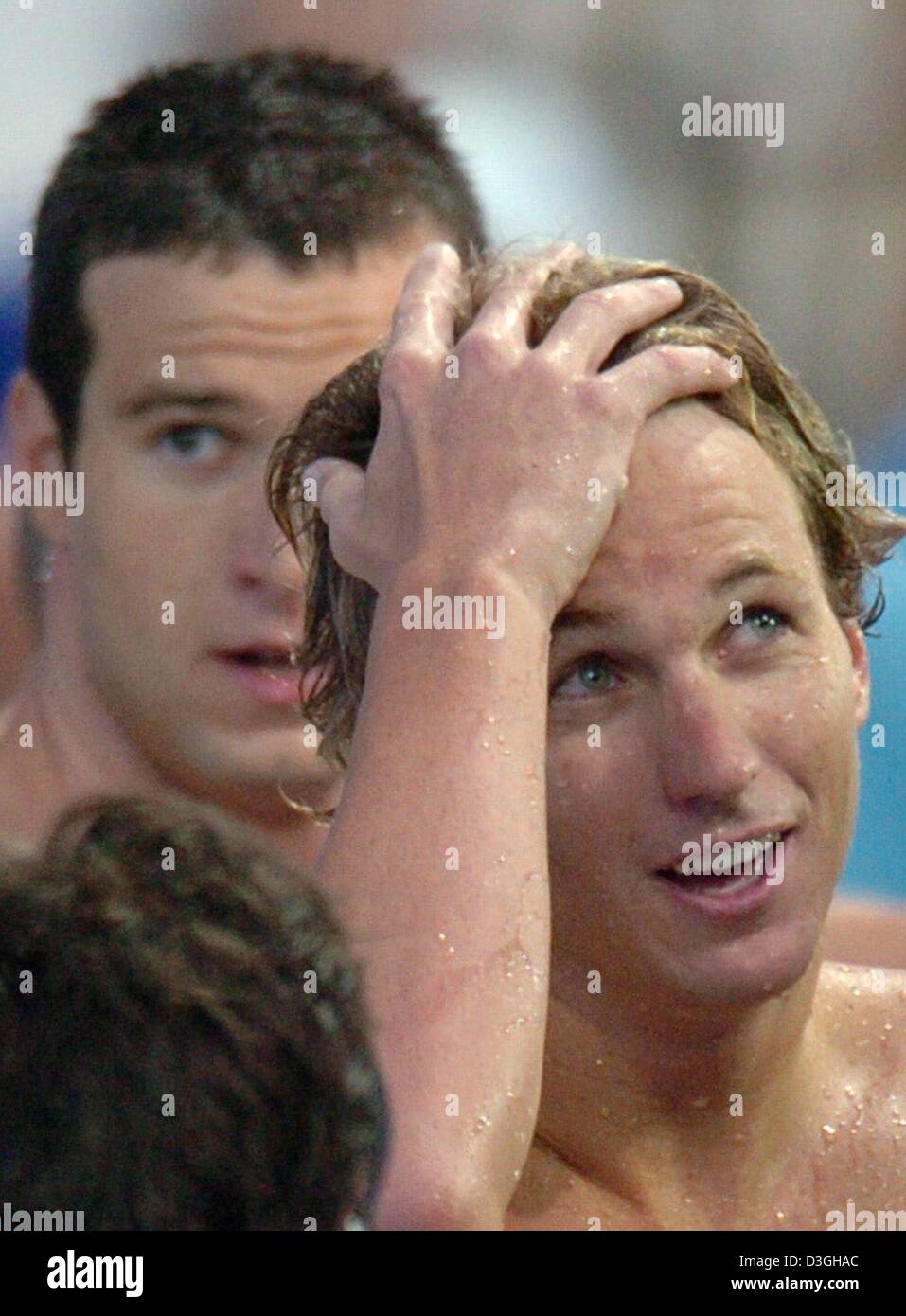 (dpa) Fastest swimmer Aaron Peirsol from the US (R) gestures next to runner up Markus Rogan from Austria after the men's 200m Backstroke Final at the Olympic Aquatic Centre in  Athens, Greece, 19 August 2004. Peirsol was initially disqualified but later, requalified after a wrong turn. Rogan took silver. Stock Photo