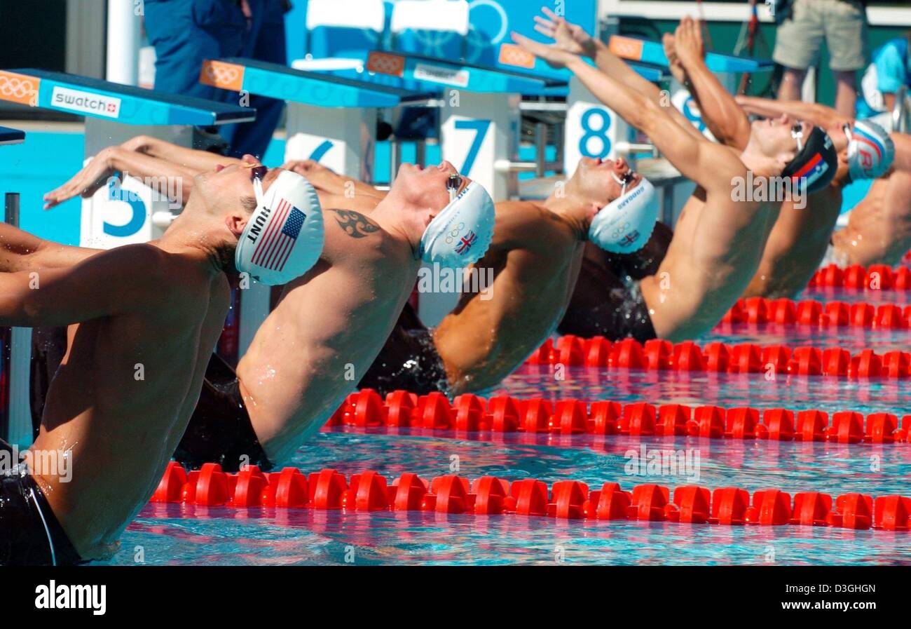(dpa) - The swimmers (from L) US Bryce Hunt, British Gregor Tait, British James Goddard and Slovenian Biaz Medvesek leap backwards at the start of the men's 200m Backstroke qualifying heat at the Olympic Aquatic Centre in Athens, Greece, 18 August 2004. Stock Photo