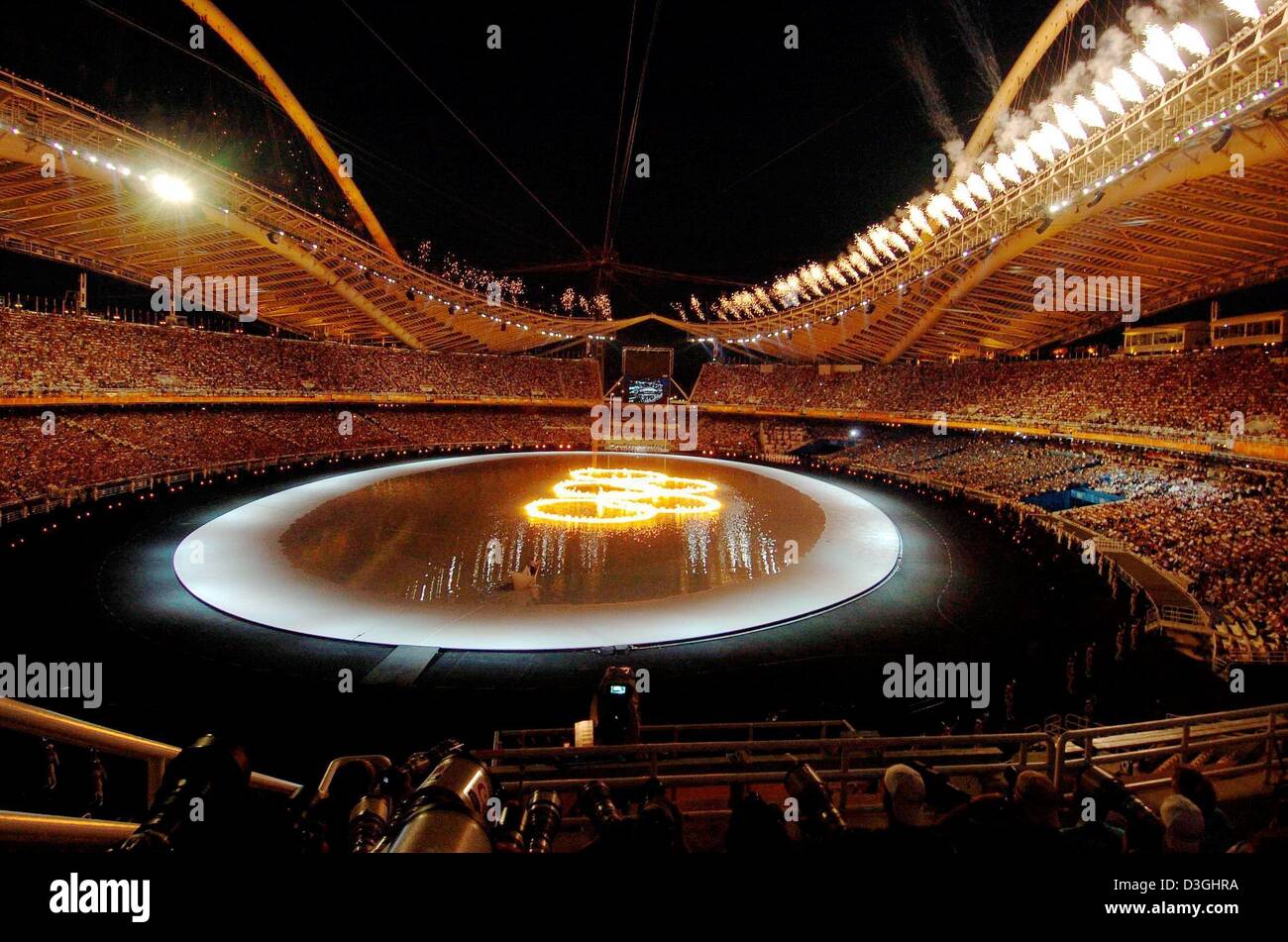 (dpa) - The Olympic Rings on fire in the Olympic Stadium during the opening ceremony of the 2004 Olympic Games in Athens, Friday 13 August 2004. More than 10.800 athletes will compete in the Olympics. Stock Photo