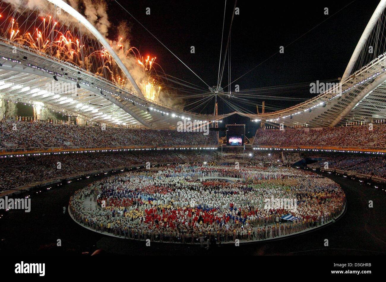 (dpa) - Olympic athletes gather in the Olympic Stadium during the fireworks at the opening ceremony of the 2004 Olympics in Athens, Friday 13 August 2004. Stock Photo
