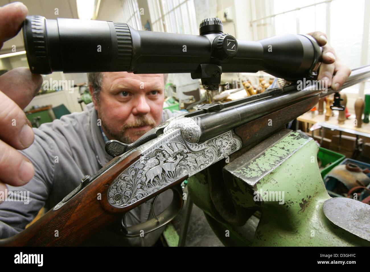 (dpa) - Erich Gerike, employee of gunsmith Knappworst, inspects a telescopic sight on a rifle at the gunsmith's workshop in Braunschweig, Germany, 15 June 2004. There are around 30 traditional gunsmiths left in the state of Lower Saxony. The new gun law requires huntsmen and sports riflemen to keep their rifles locked up in special armour cabinets. Stock Photo