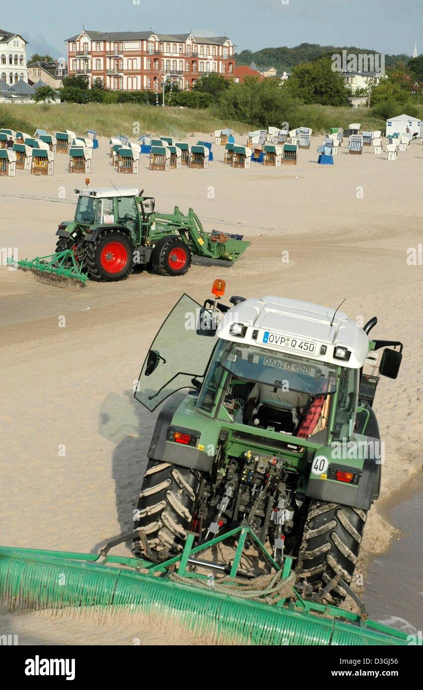 (dpa) - Two tractors pulling oversized rakes clean the beach in Ahlbeck ...
