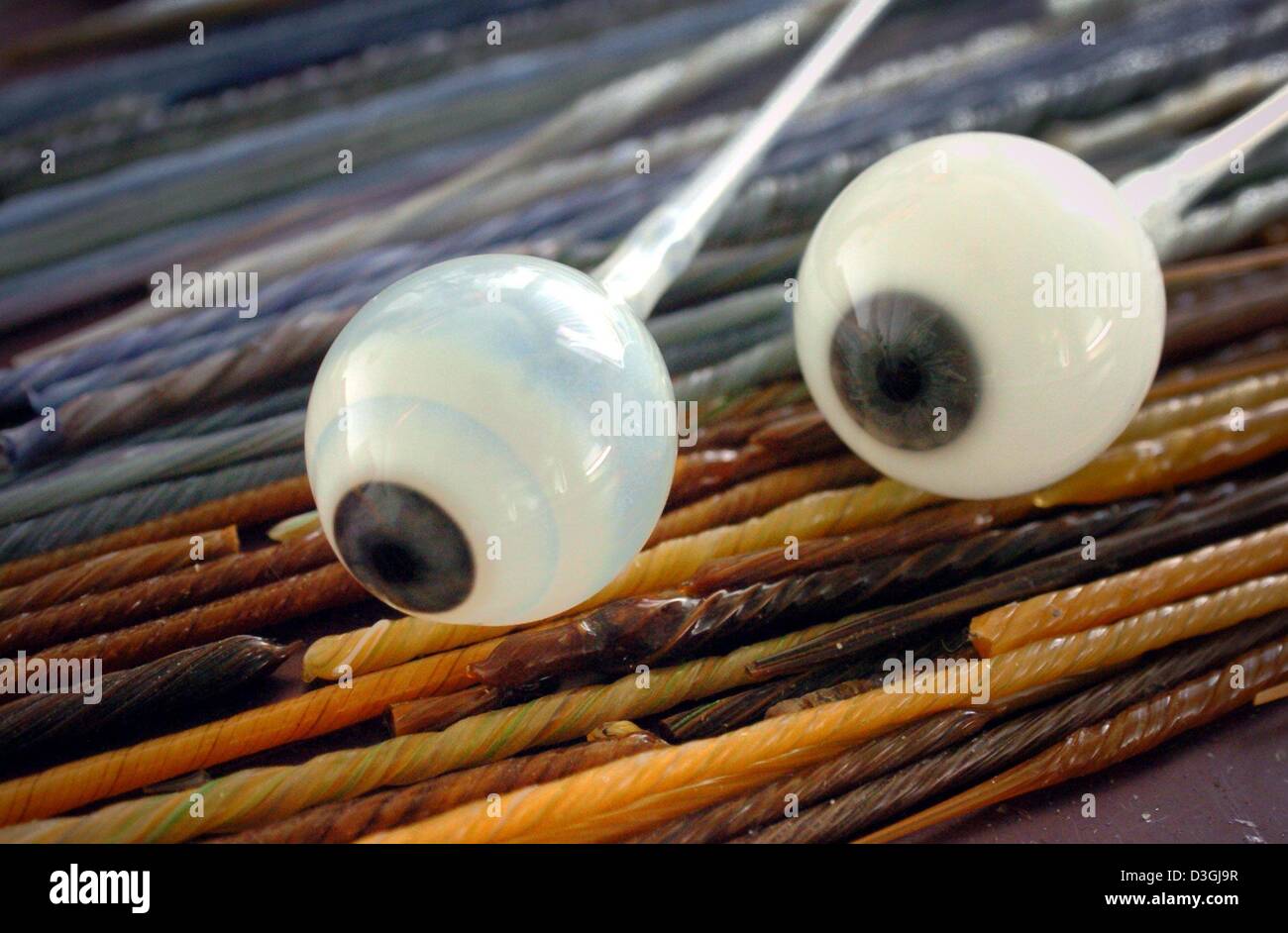 (dpa) - Two not yet finished glass eyeballs lie on coloured glass sticks at Augenprothetik Lauscha eye prostheses manufacturer in Lauscha, Germany, 3 August 2004. The coloured glass sticks are used for the replication of the iris on the glass eyeballs. Artificial glass eyes were invented and first produced in 1835 by Ludwig Mueller-Uri in Lauscha, eastern Germany. The eyes are prod Stock Photo