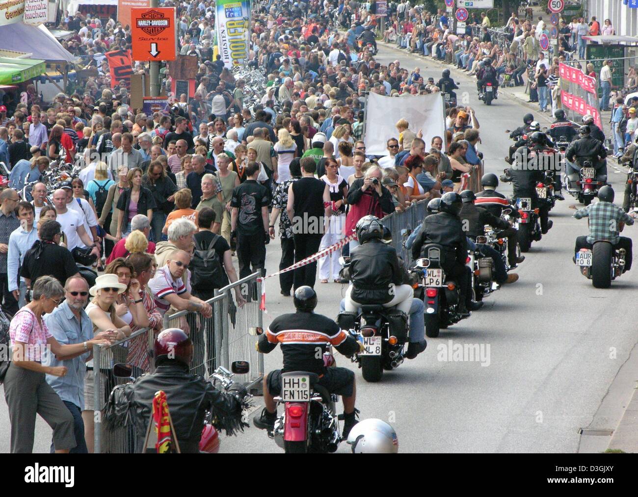 (dpa) Visitors watch a parade of HarleyDavidson motorcycles riding along one of the main