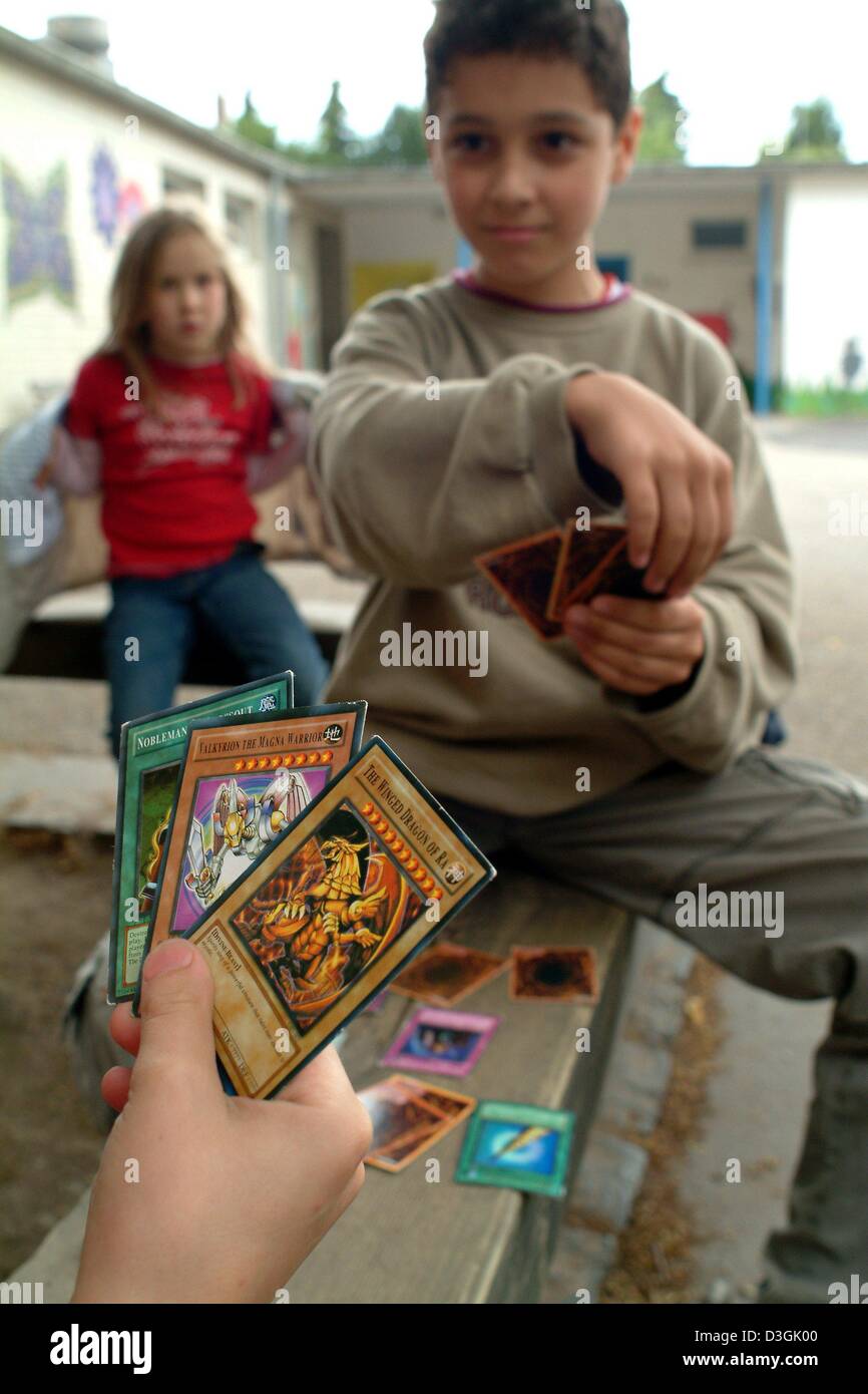 (dpa) - Two boys play with YuGiOh cards in their schoolyard in Frankfurt, Germany, 13 July 2004. YuGiOh comes from Japan and debuted in 1996 as a comic book series about a game player with mystical powers. Stock Photo