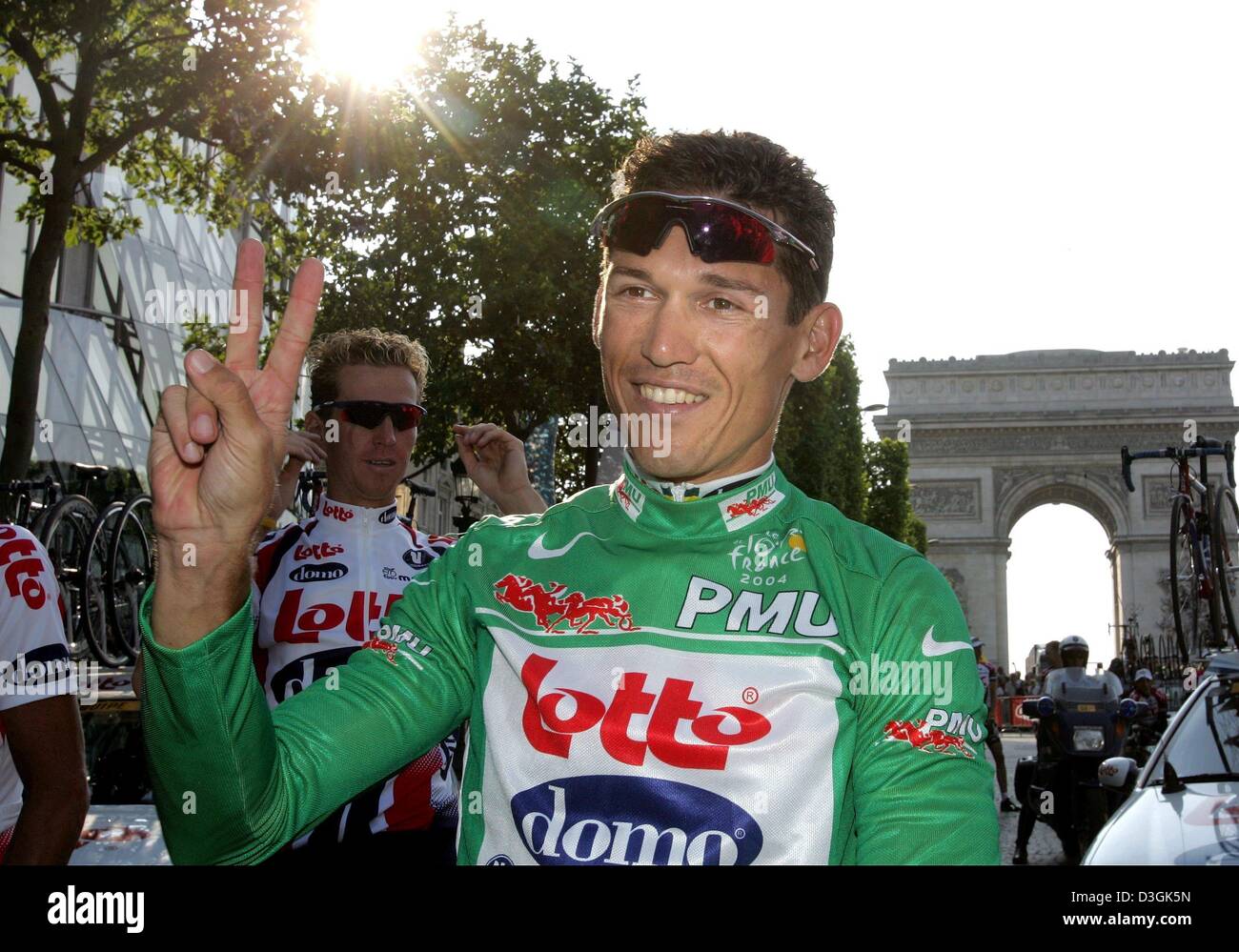 (dpa) - Australian cyclist Robbie McEwen of team Lotto-Domo celebrates winning the green jersey of the best sprinter by making the victory sign after the end of the last stage of the 2004 Tour de France cycling race in Paris, France, 25 July 2004. McEwen won the green jersey for the second time. The 163 km long final stage of the 91st Tour de France led from Montereau to the famous Stock Photo