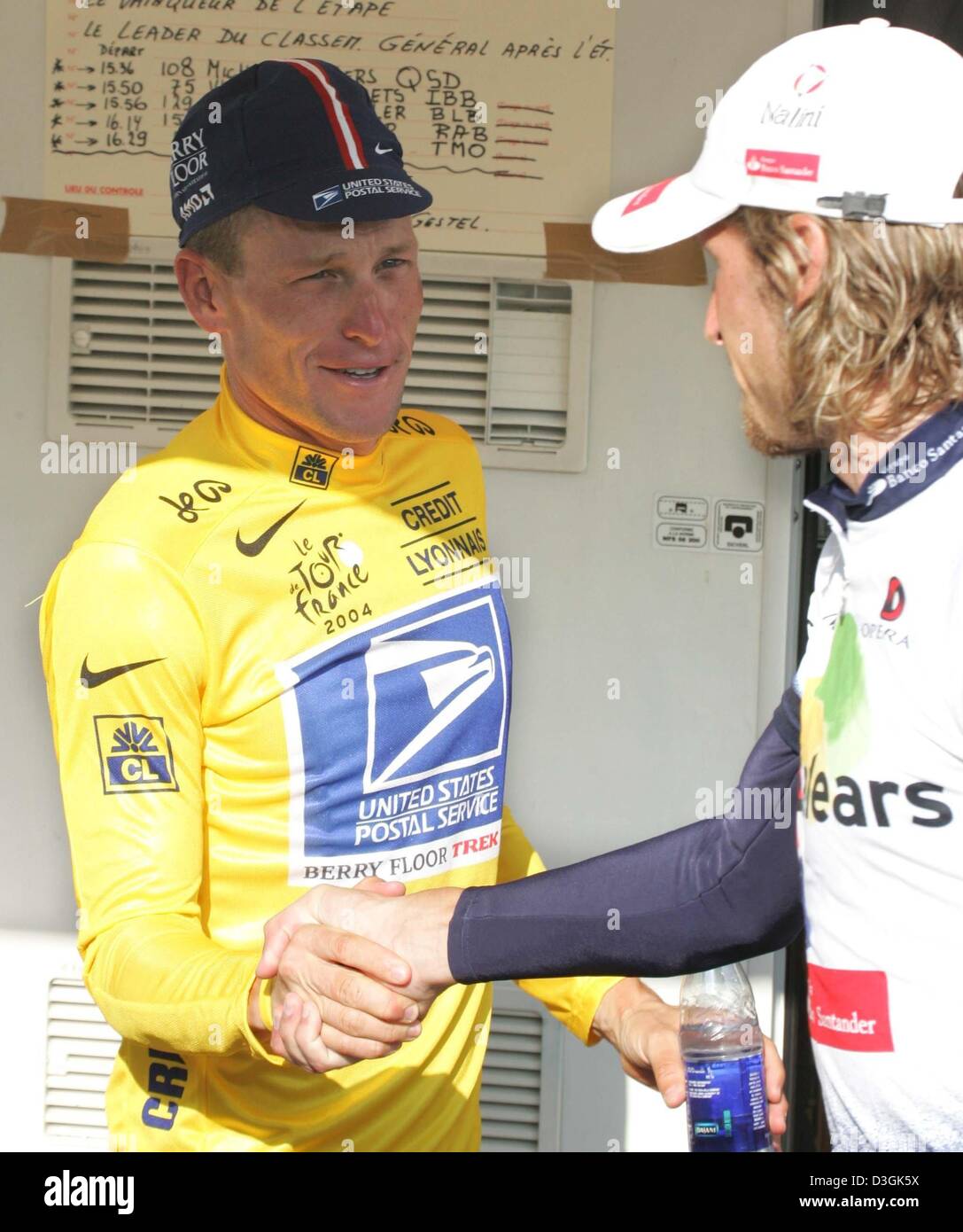 (dpa) - US Postal team rider Lance Armstrong from the US (L), wearing the race leader's yellow jersey, congratulates Russian Vladimir Karpets of Illes Balears, wearing the best young rider's white jersey, following the 19th stage of the Tour de France cycling race, in Besancon, France, 24 July 2004. Stock Photo