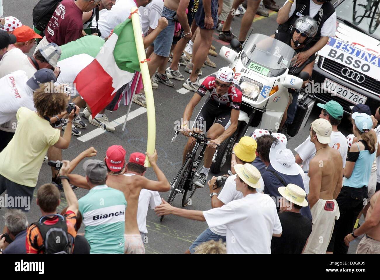 (dpa) - Italian rider Ivan Basso of Team CSC on his bicycle along a narrow alley of cheering fans during the 16th stage of the Tour de France towards L'Alpe d'Huez, France, 21 July 2004. This traditional stretch is a 15.5 km long mountain time trial which consists of 21 serpentines with a difference in elevation of 1130 metres from Bourg-d'Oisans to the winter ski resort of Ski-Ort Stock Photo