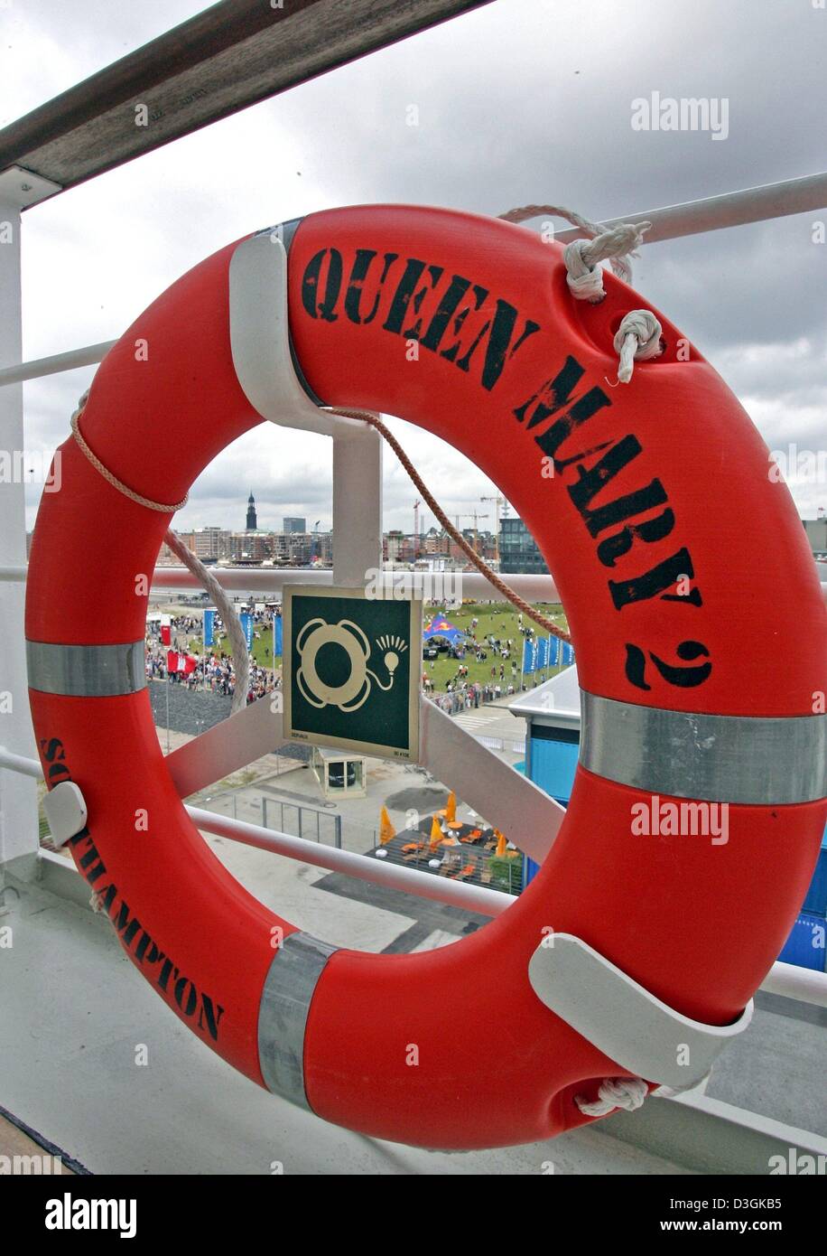 (dpa) - A lifebelt hangs on the railing of the luxury cruise liner 'Queen Mary 2' which is docking at the pier of the harbour in Hamburg, Germany, 19 July 2004. The 'Queen Mary 2', which was built at a cost of 800 million dollars, is the flagship of the British Cunard shipowning company. The vessel is 345 metres long, the length of the Eiffel Tower, and accommodates up to 2620 pass Stock Photo