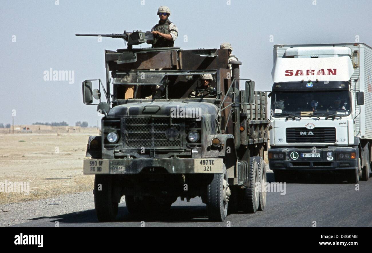 (dpa) - US soldiers of the 497 Transport Company travel on a modified armoured lorry along the road east of Baji, Iraq, 03 June 2004. The lorry is equiped with 12,7mm M 2A2HB machine guns and is being used to protect supply convoies. Stock Photo
