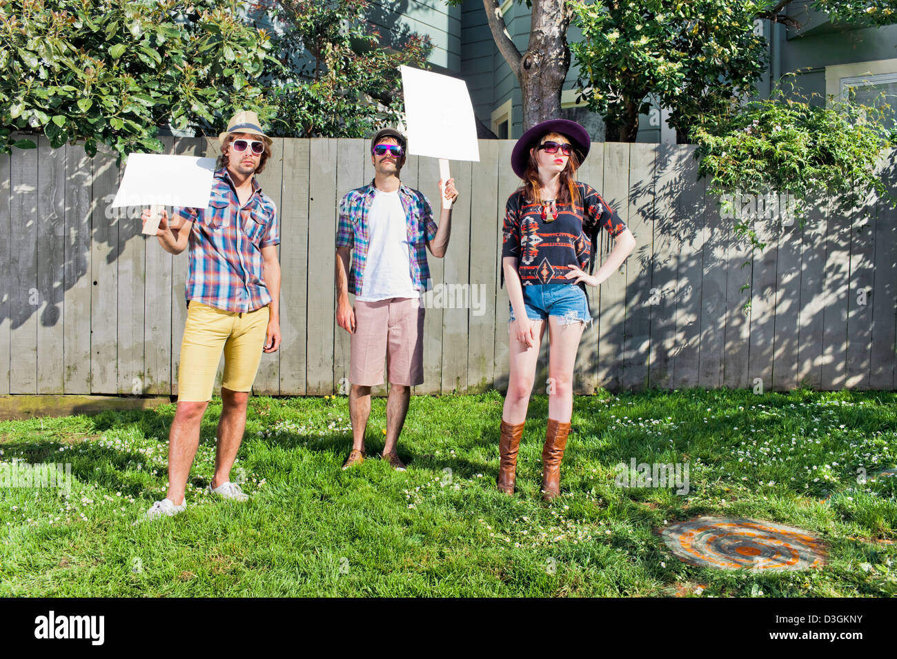 Hipsters and Beatniks - Three hipsters demonstrating while holding blank placards, signs Stock Photo