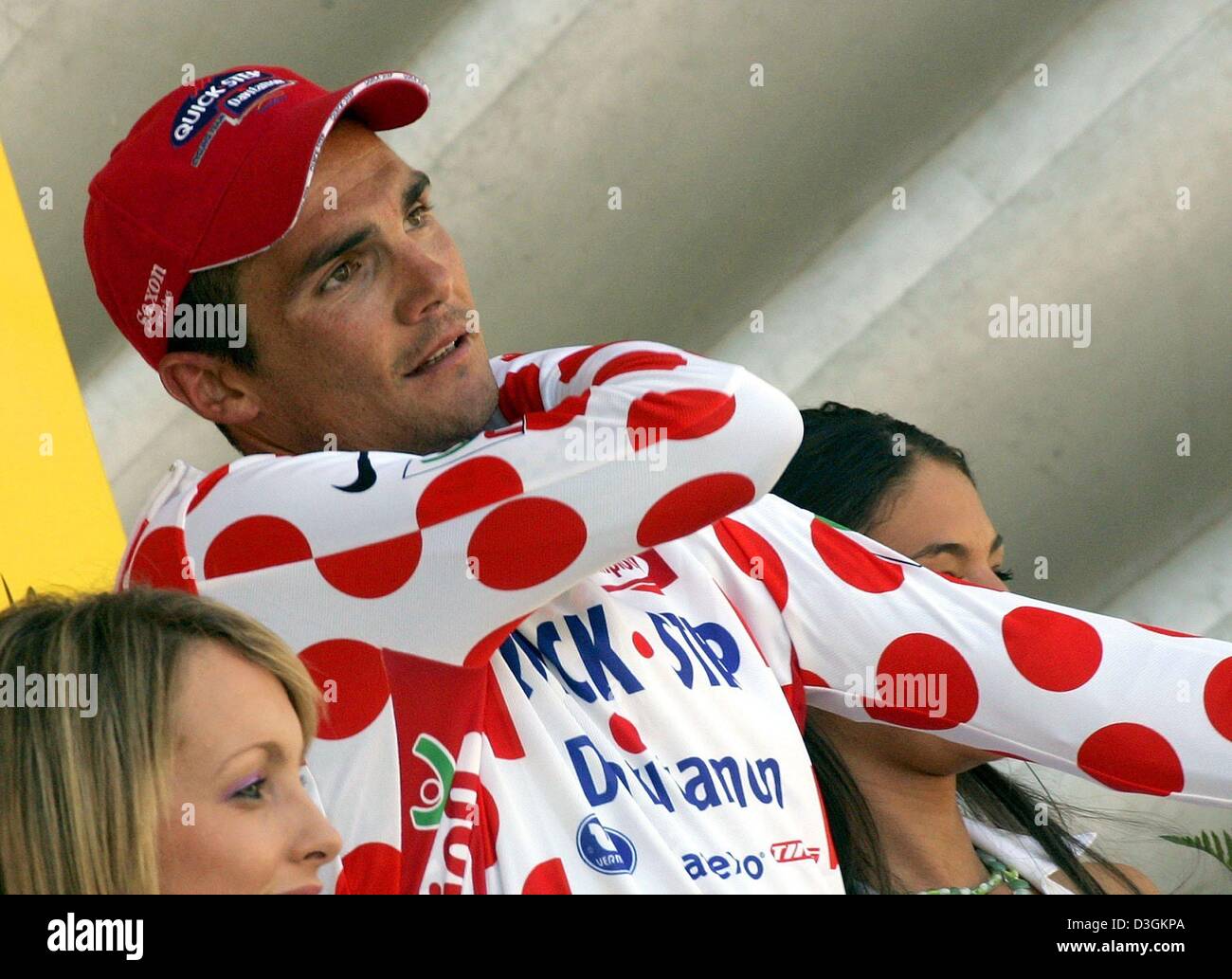 (dpa) - French cyclist Richard Virenque of team Quick Step-Davitamon puts on the best climber's white and red polka-dotted jersey after the tenth stage of the Tour de France cycling race in Saint-Flour, France, 14 July 2004. The 237km long first mountain stage took the cyclists from Limoges through the Massif Central to Saint-Flour. Virenque also won the stage. Stock Photo