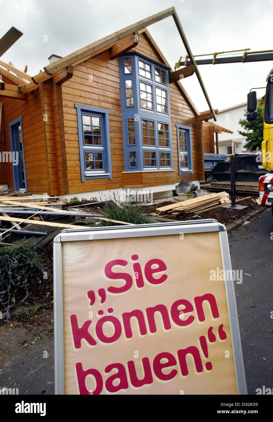 (dpa) - 'Sie koennen bauen' (you can built) says a sign in front of a model house that is under construction at the 'Eigenheim und Garten' (home and garden) fair in Bad Vilbel, Germany, 14 July 2004. The German government announced that it aims to completely abolish the current subsidies for private home builders and use the saved money for a program that honours innovative busines Stock Photo