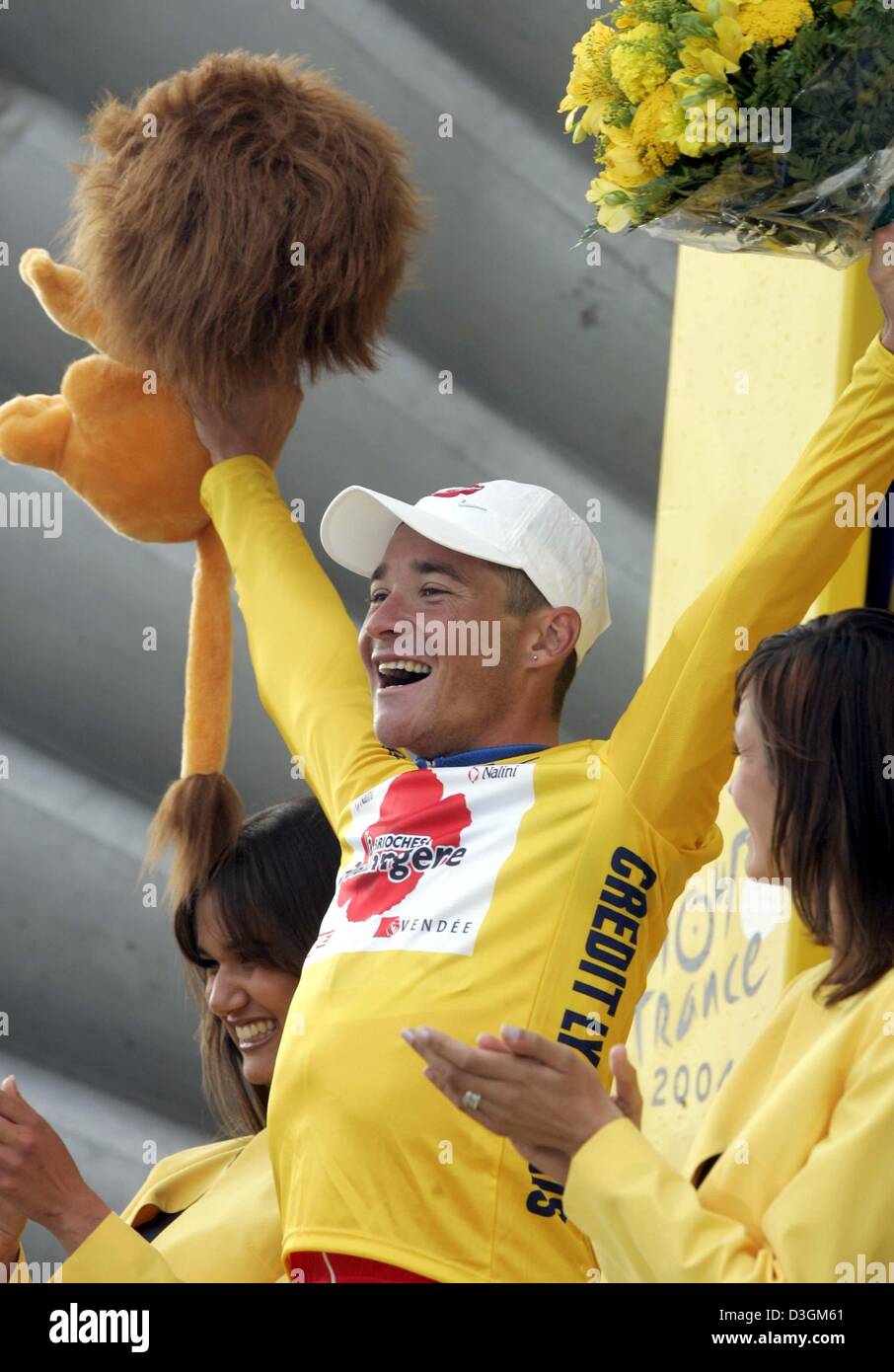 (dpa) - French cyclist Thomas Voeckler (C) of Team Brioches La Boulangere cheers and smiles as he wears the yellow jersey of the front runner after the fifth stage of the Tour de France cycling race in Chartres, France, 8 July 2004. The 25-year-old cyclist arrived fourth at the finishing line. The 200.5km long fifth stage of the Tour de France led the cyclists from Amiens to Chartr Stock Photo