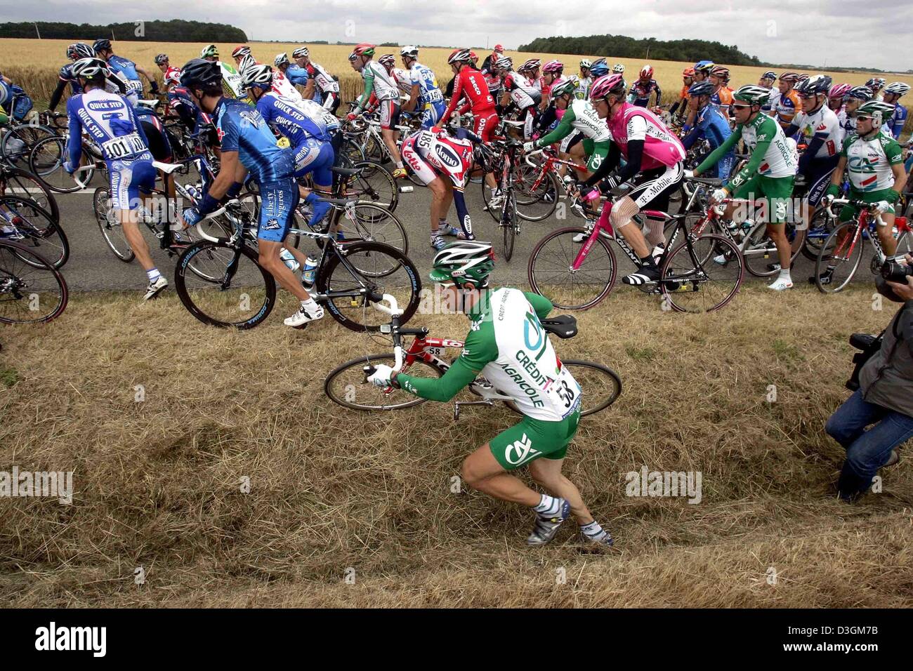 (dpa) - Several cyclists have to bypass other riders who fell with their bicycles during the 6th stage of the Tour de France near Bonneval France, 09 July 2004. In the ditch New Zealand's cyclist Juian Dean of Team Credit Agricole. Among those who fell off their bicycles was US rider Lance Armstrong of Team US Postal Service but he managed to catch up again with the help of his tea Stock Photo