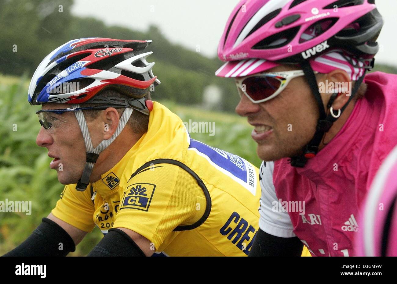(dpa) - US cyclist Lance Armstrong (L) of team US Postal Services wearing the yellow jersey races head to head with Germany's Jan Ullrich of team T-Mobile early during the 5th stage of the Tour de France cycling race leading from Amiens to Chartres, France, 8 July 2004. Ullrich lags 55 seconds behind in the overall standings. Stock Photo