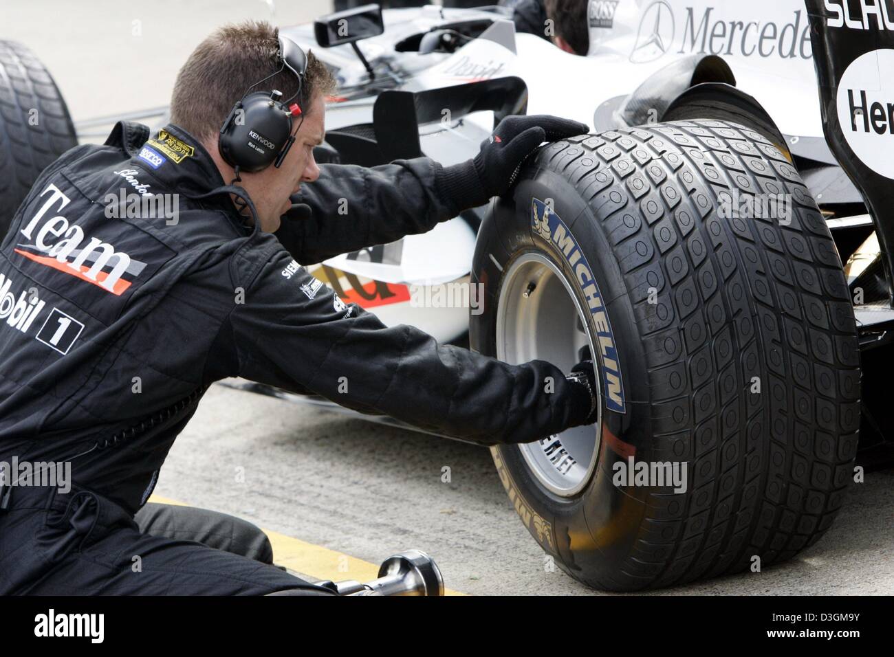 dpa) - A McLaren-Mercedes mechanic screws a rain tyre onto the wheel rim of  David Coulthard's race car at the Silverstone race course in Silverstone,  Great Britain, Thursday 8 July 2004. On